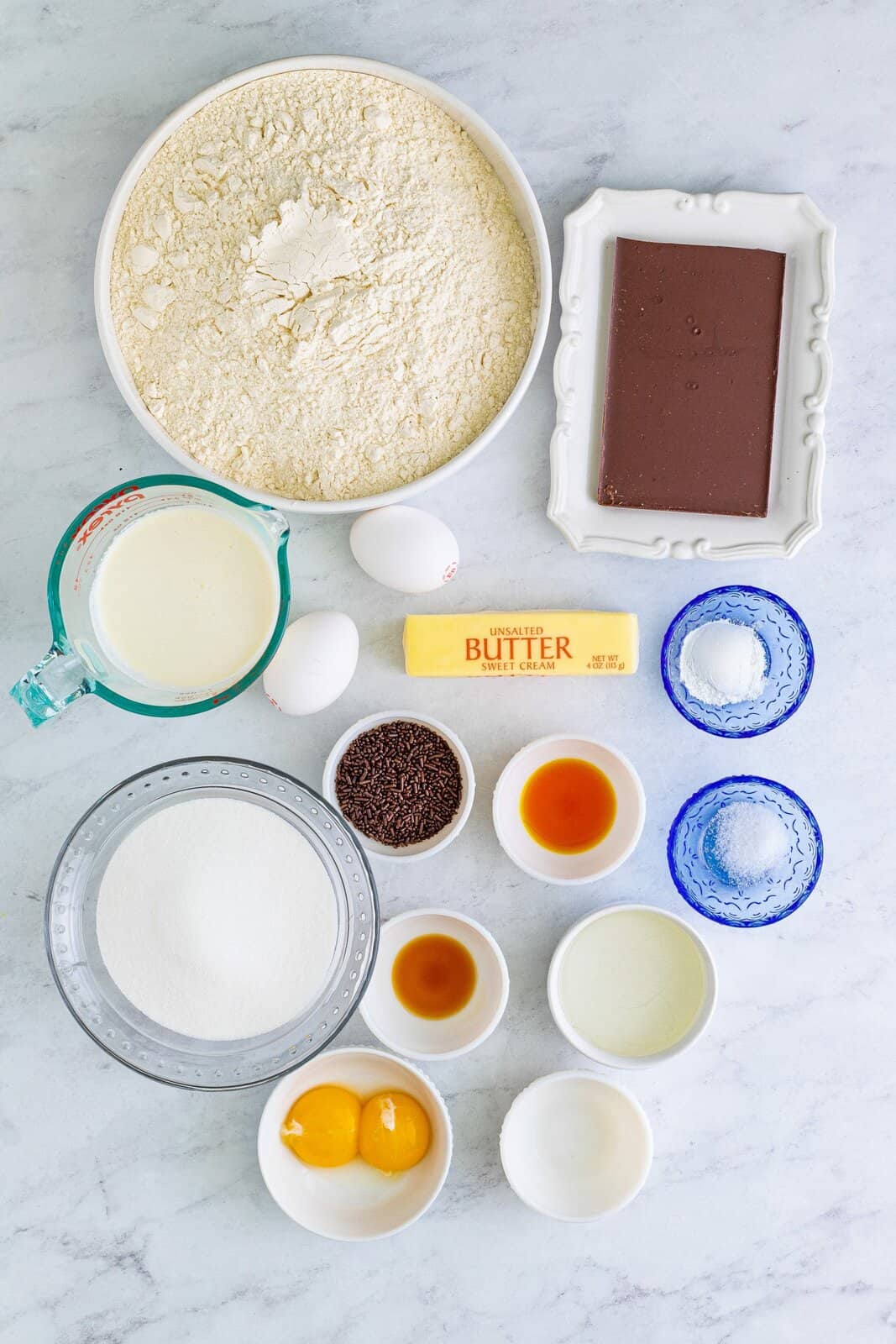 Ingredients needed: all-purpose flour, baking powder, fine sea salt, unsalted butter, granulated sugar, eggs, egg yolks, cake batter extract, almond extract, vanilla extract, semi-sweet chocolate baking bars, heavy cream, light corn syrup and chocolate sprinkles.
