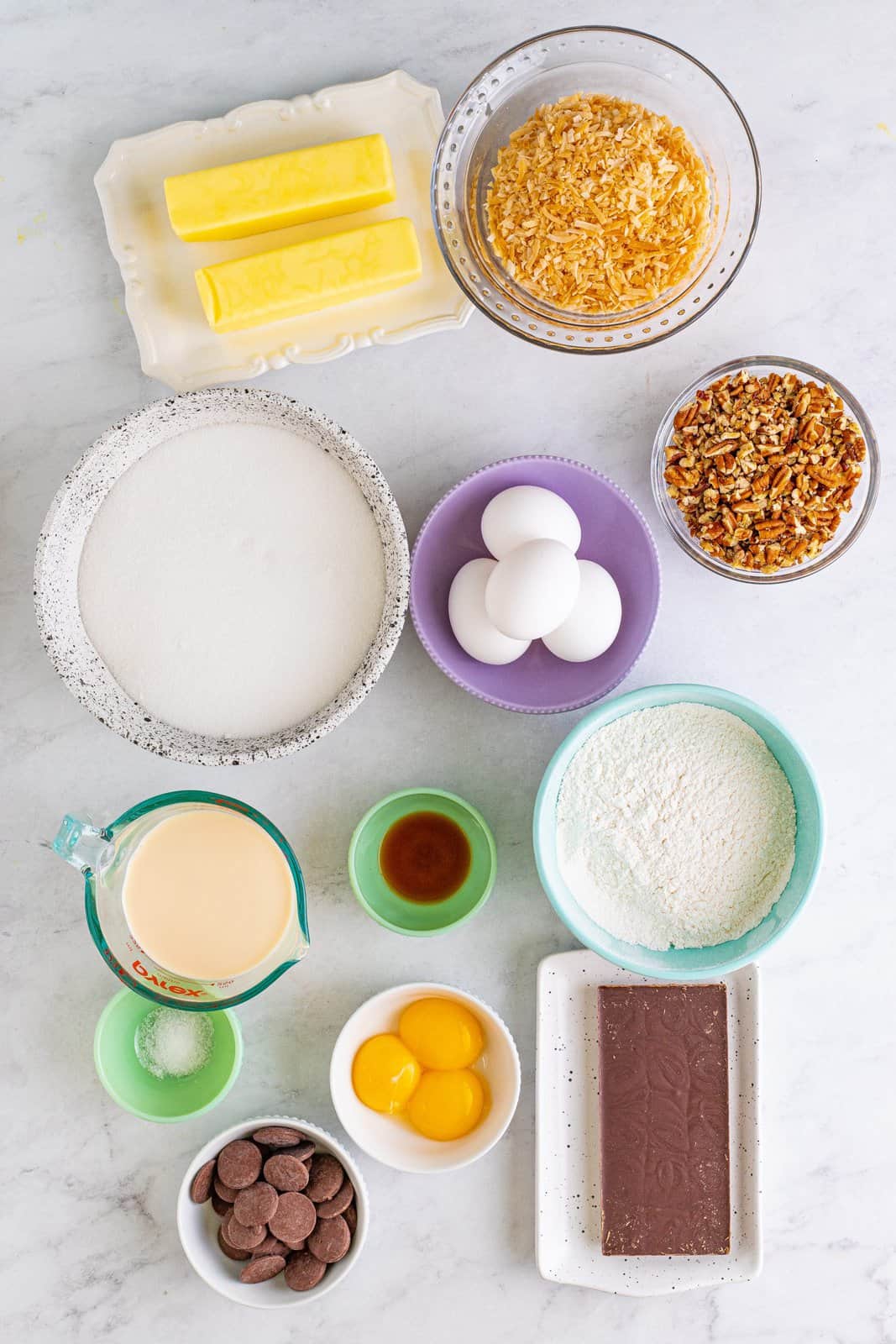 Ingredients needed: salted butter, german chocolate baking bar, granulated sugar, eggs, vanilla extract, fine sea salt, all-purpose flour, evaporated milk, egg yolks, toasted coconut, chopped pecans and chocolate melting wafers.