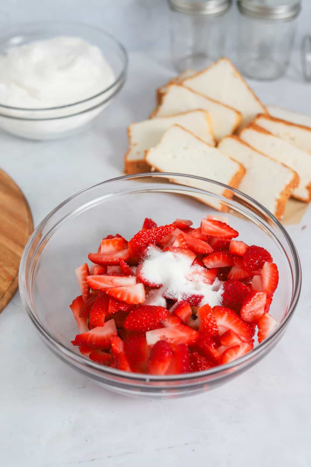 Strawberries and sugar added to bowl.
