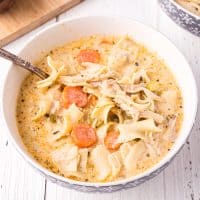Close up square image of Creamy Chicken Noodle Soup in bowl with spoon.
