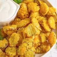 Close up overhead photo of Fried Pickles on white plate with ranch.