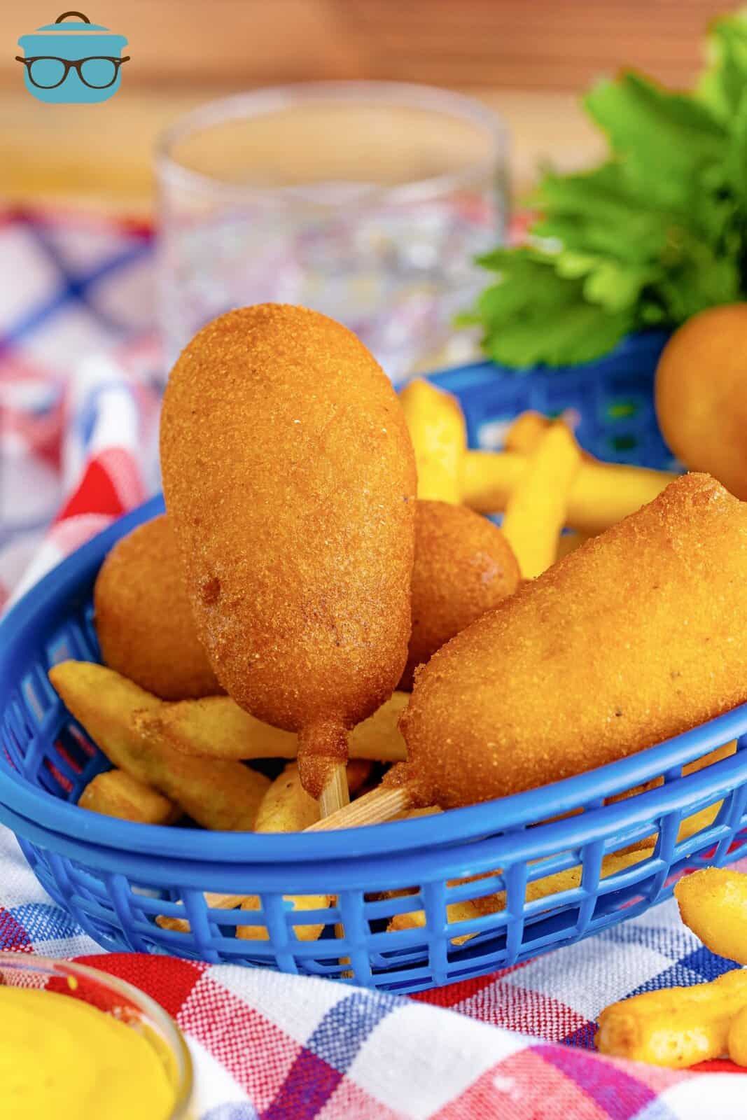 Mini Homemade Corn Dogs in blue basket on top of French fries.