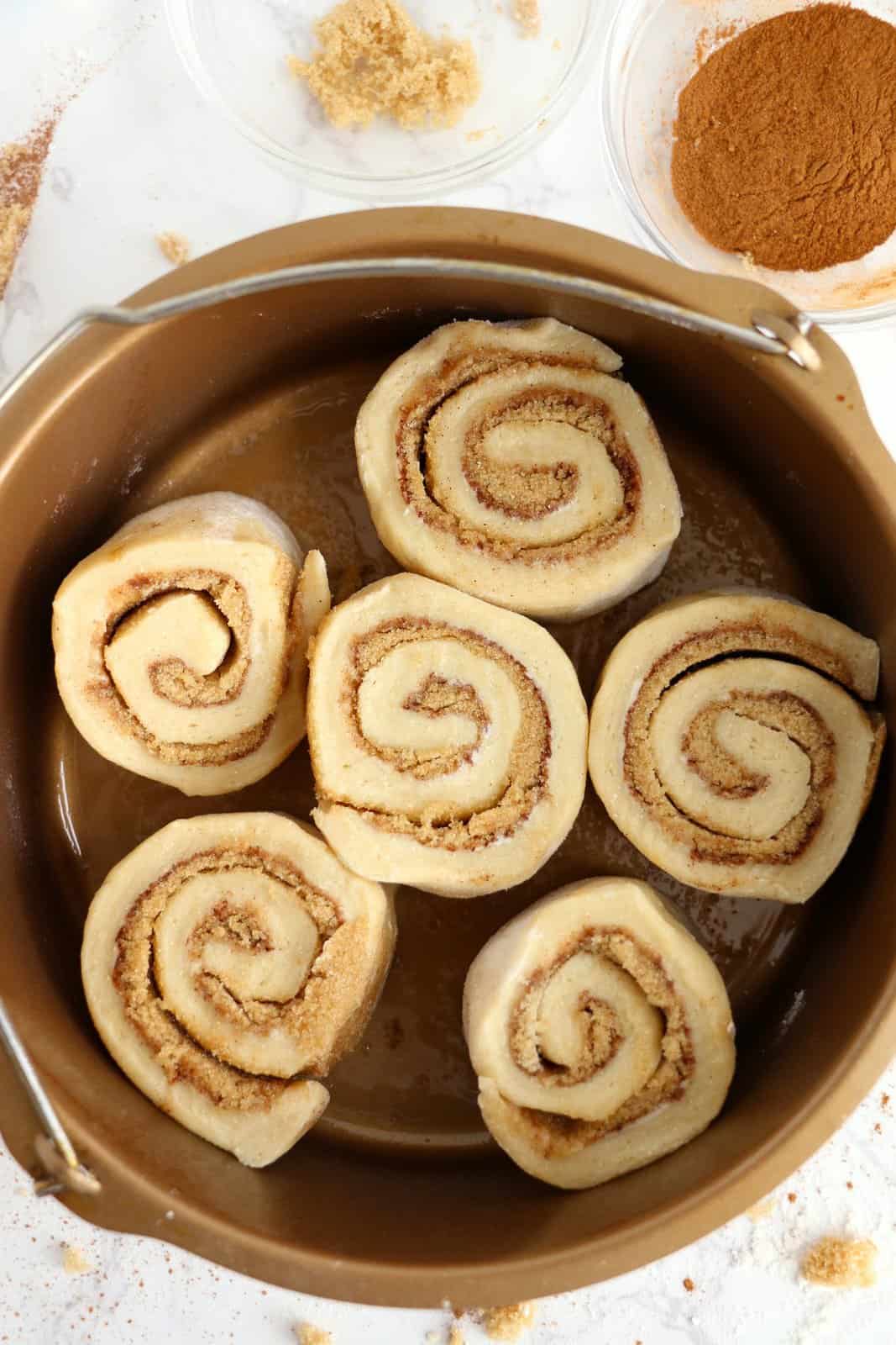 Cut rolls placed into prepared dish for air fryer.