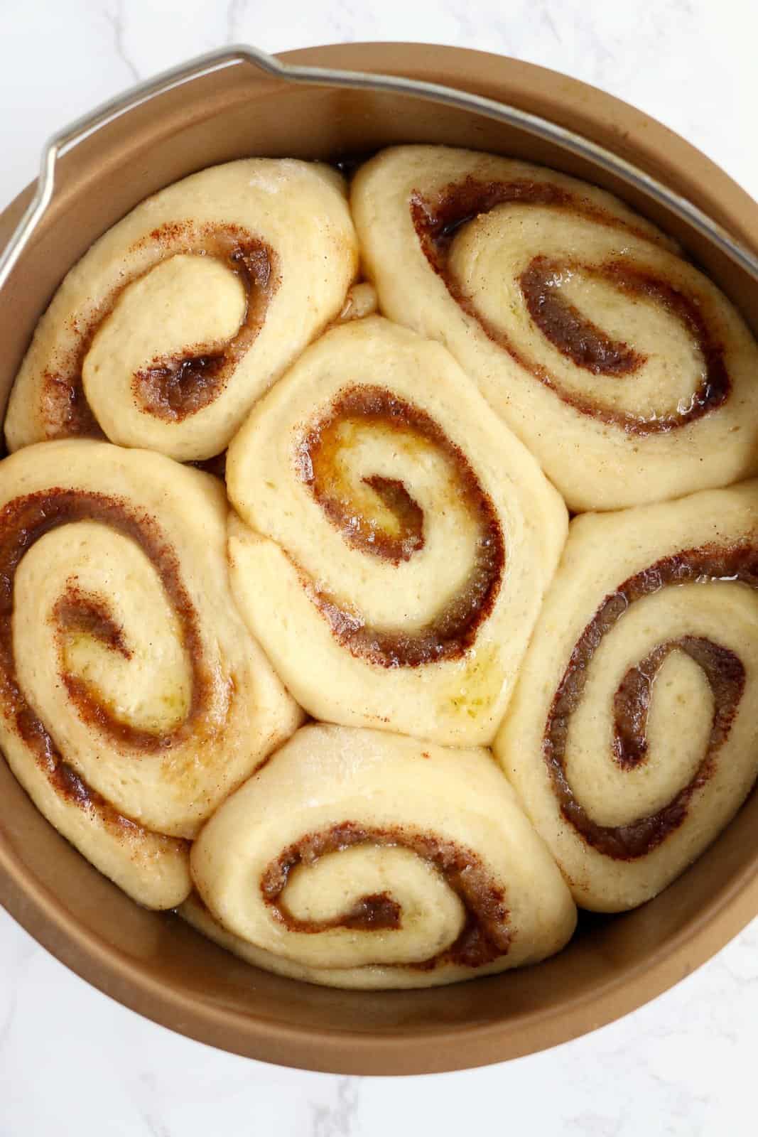 Cinnamon rolls after they have risen in prepared pan.