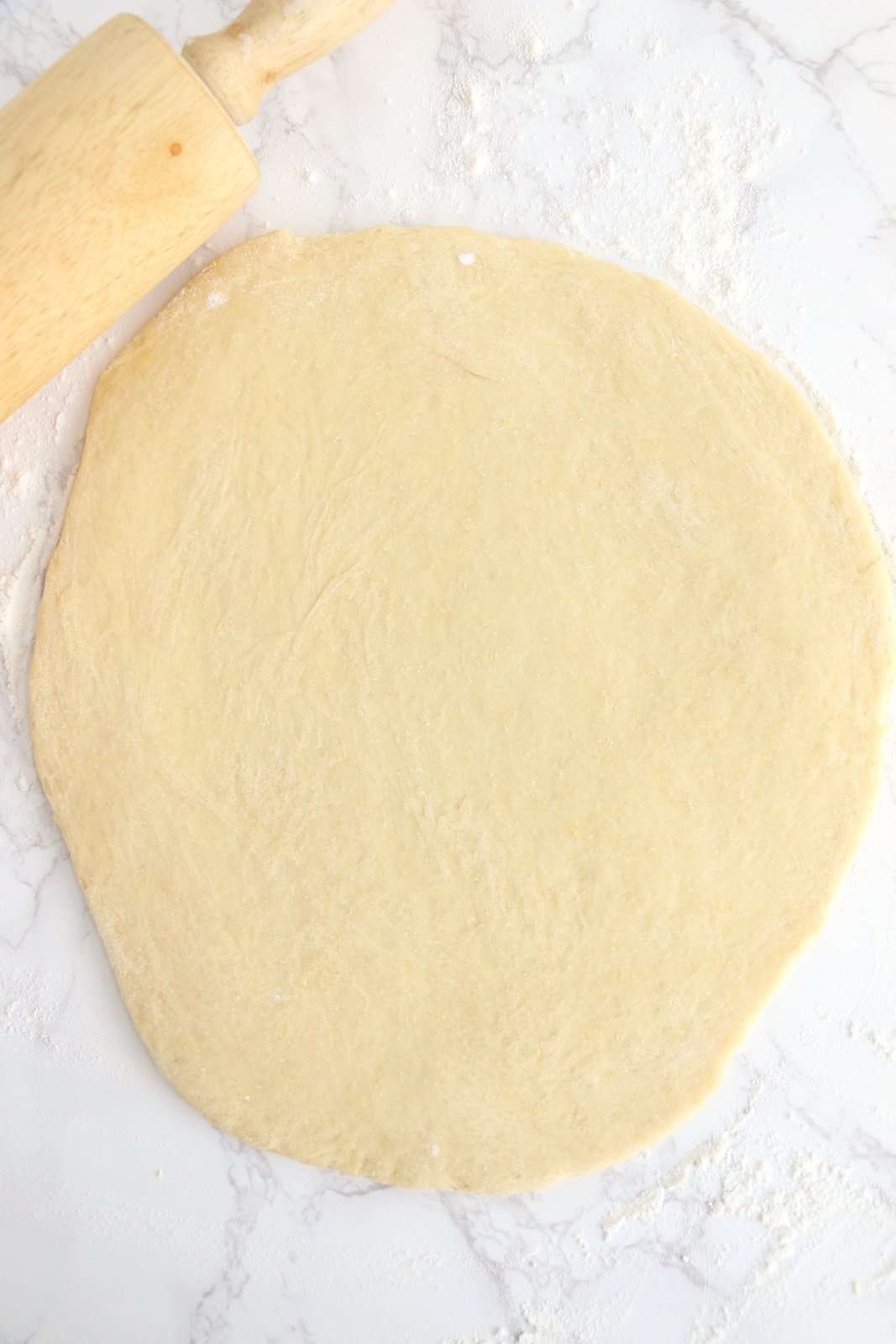 Dough rolled out on hard surface.