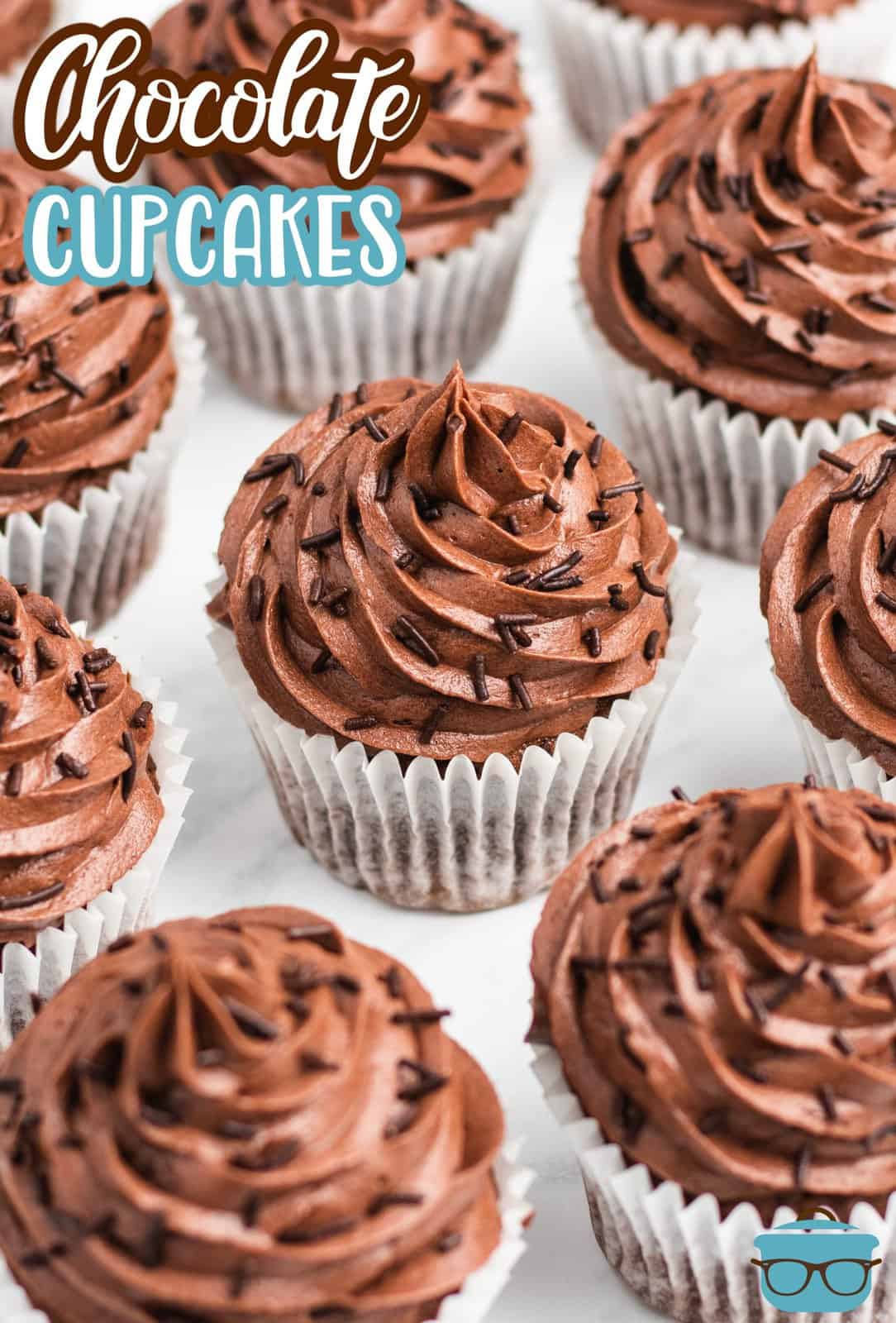 Pinterest image slightly overhead of Easy Chocolate Cupcakes on marble showing sprinkle garnishes.