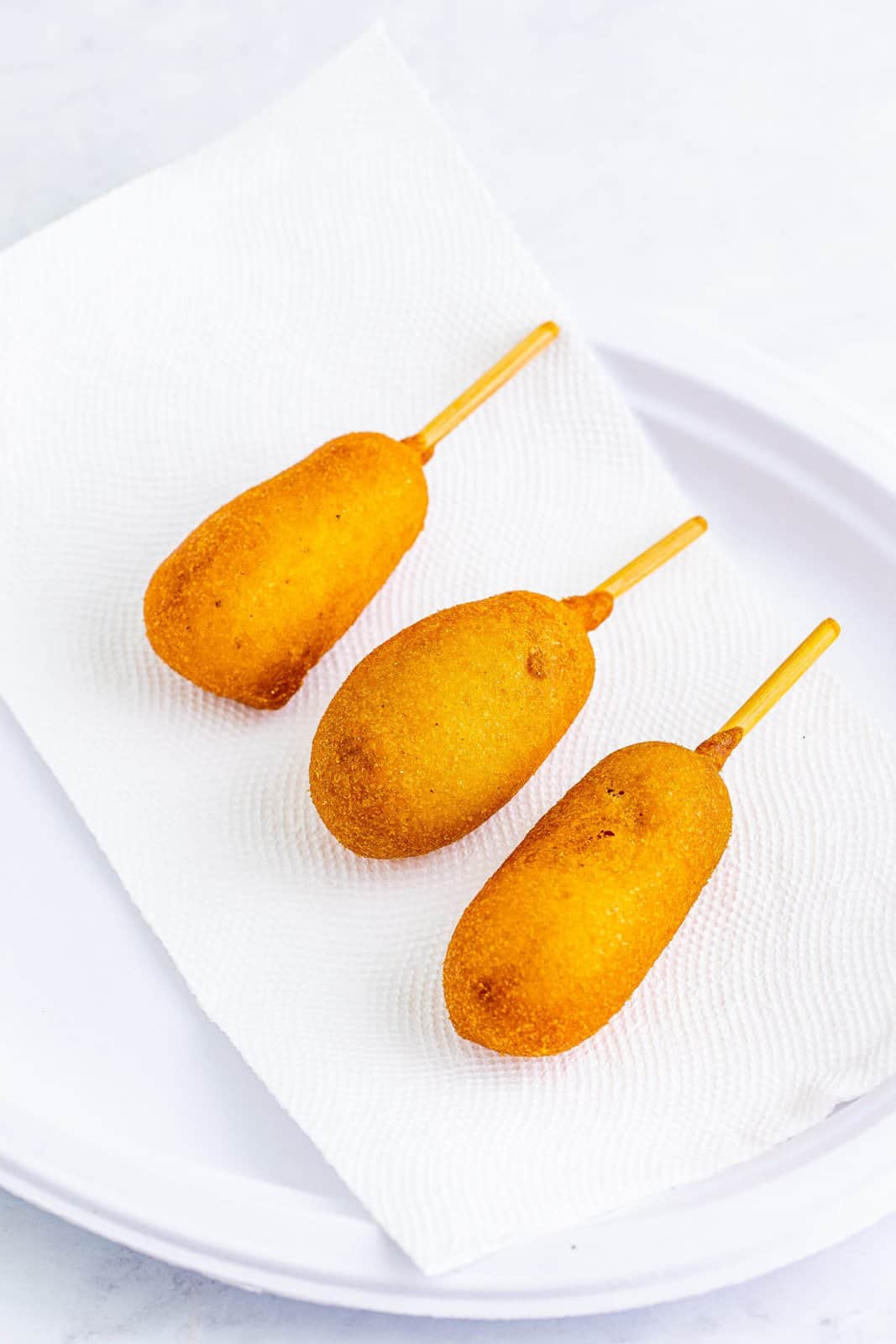 Corn Dogs draining on paper towels.