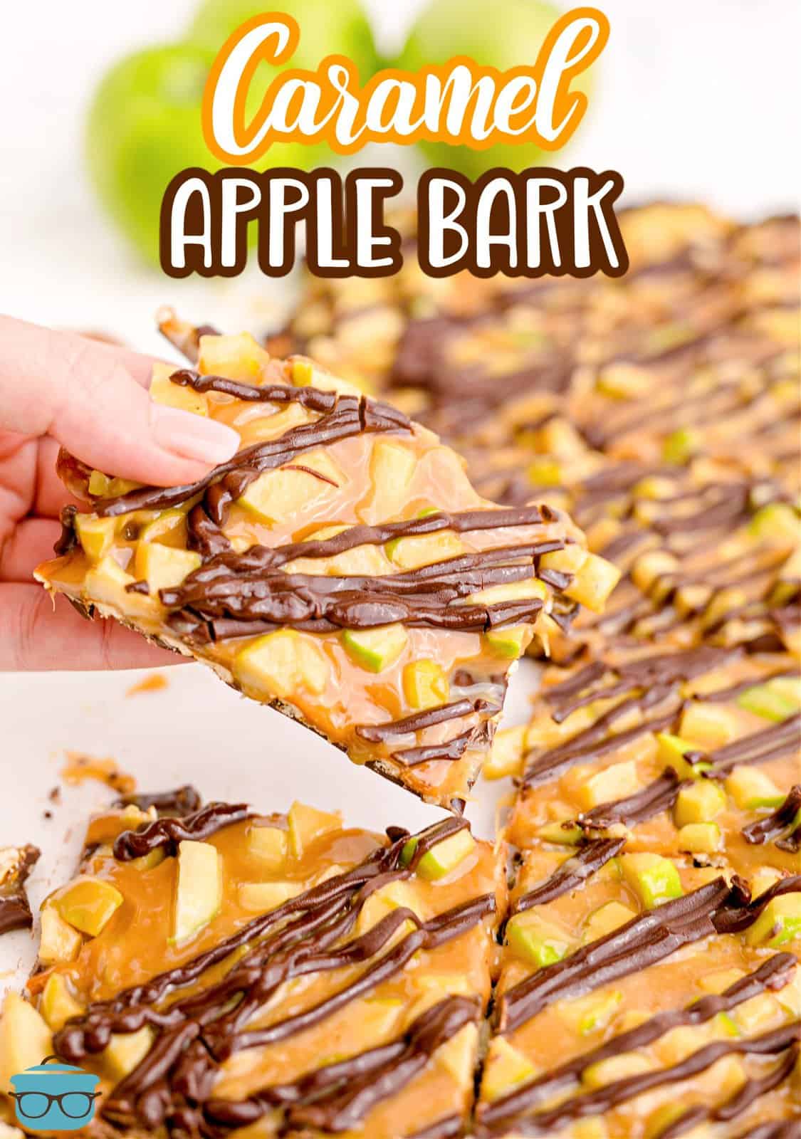 Pinterest image of a hand holding up a slice of the Caramel Apple Bark.