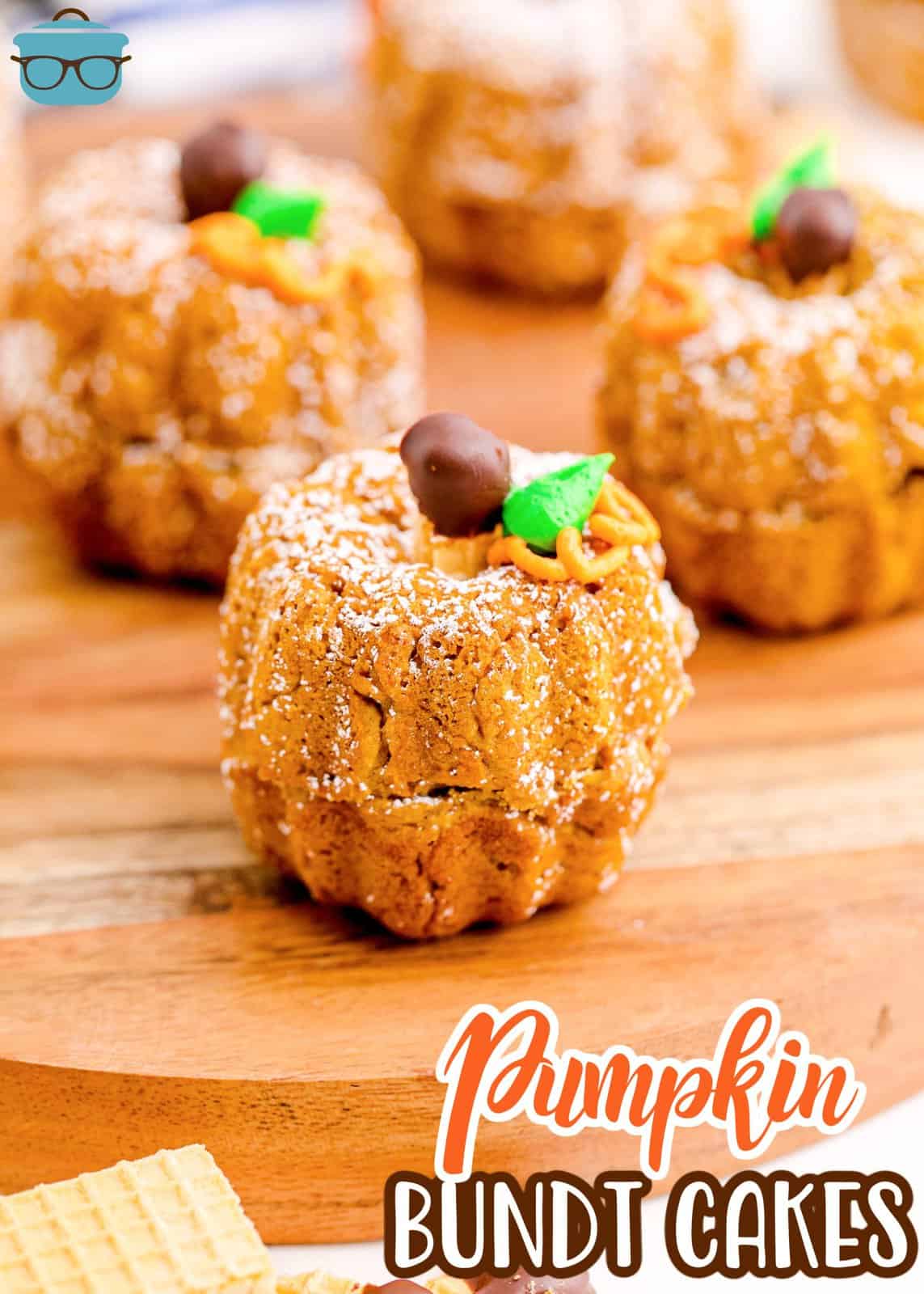 Pinterest image of Mini Pumpkin Bundt Cakes on wooden platter showing decorations.