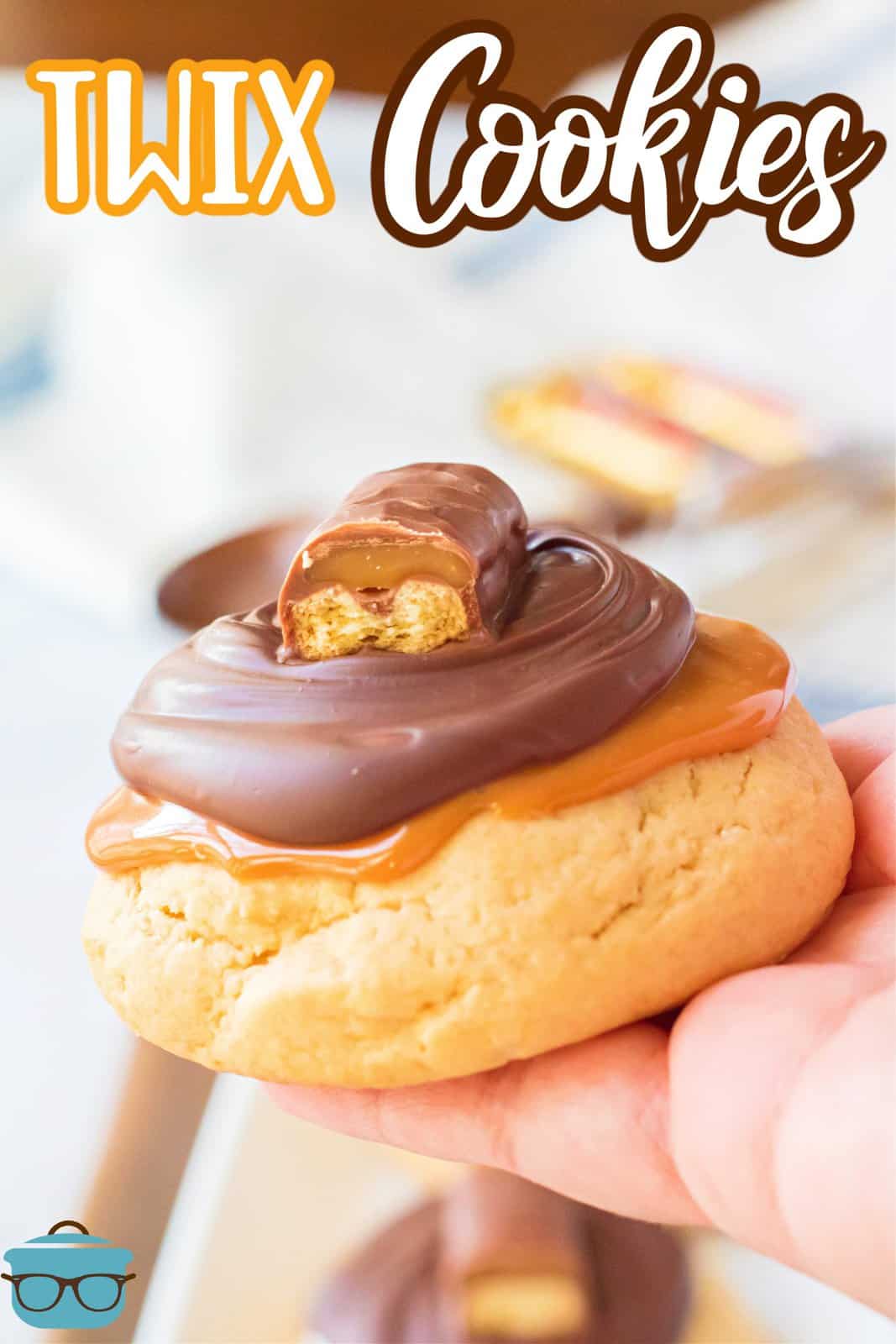 Hand holding up one of the Twix Cookies showing all the layers, Pinterest image.