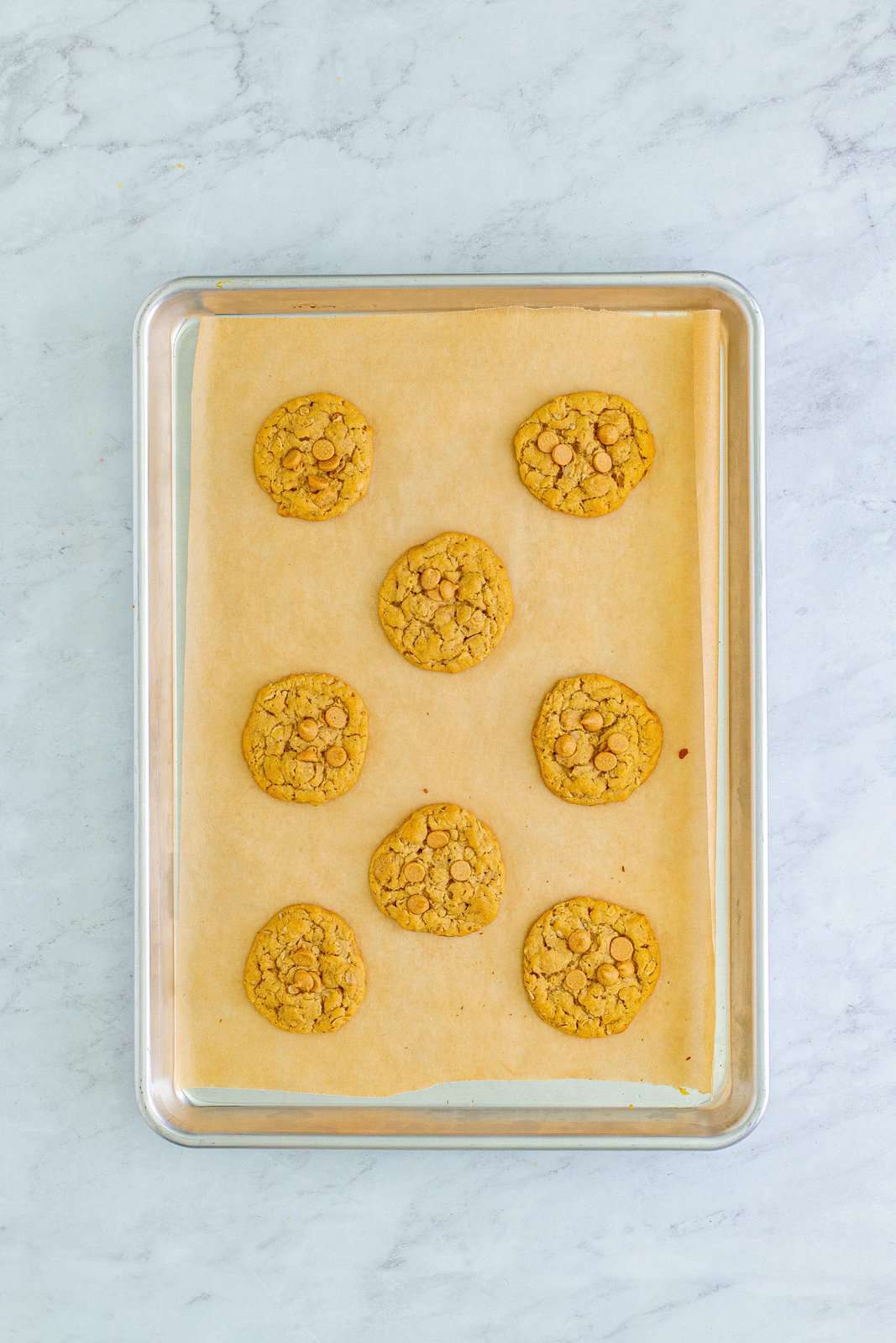 Baked cookies on parchment lined baking sheet.