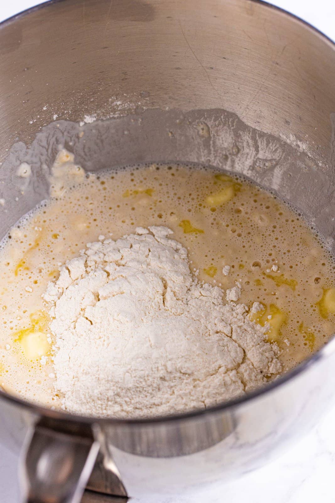 Flour being added to bowl of stand mixer.