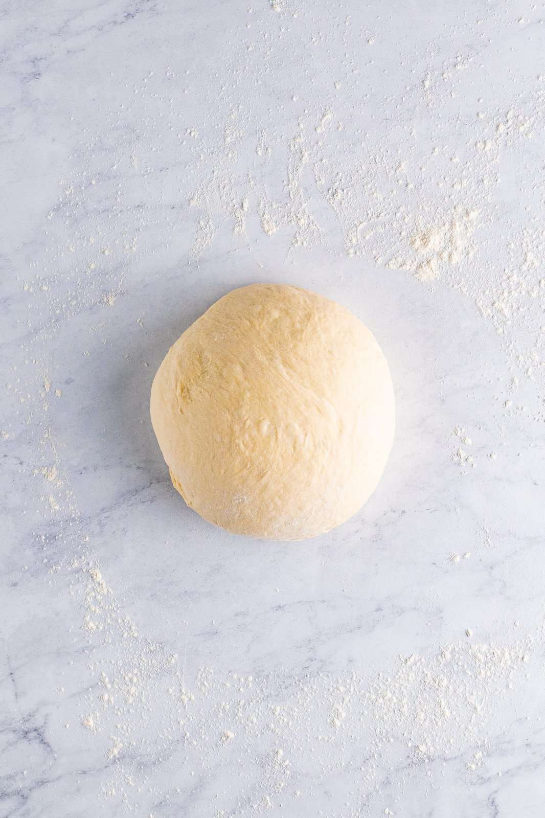 Kneaded dough on floured surface.
