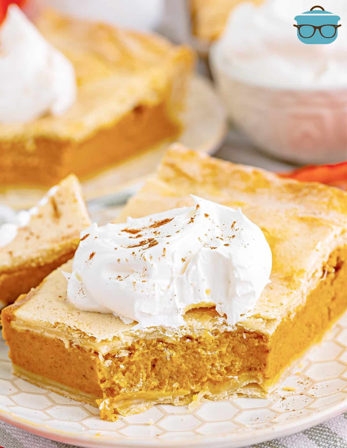 slice of pumpkin slab pie on a white plate with a bite taken out.