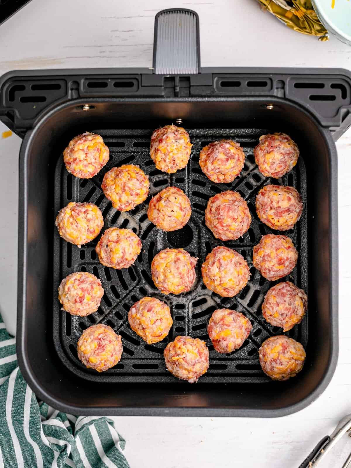 Rounded balls placed in air fryer basket.