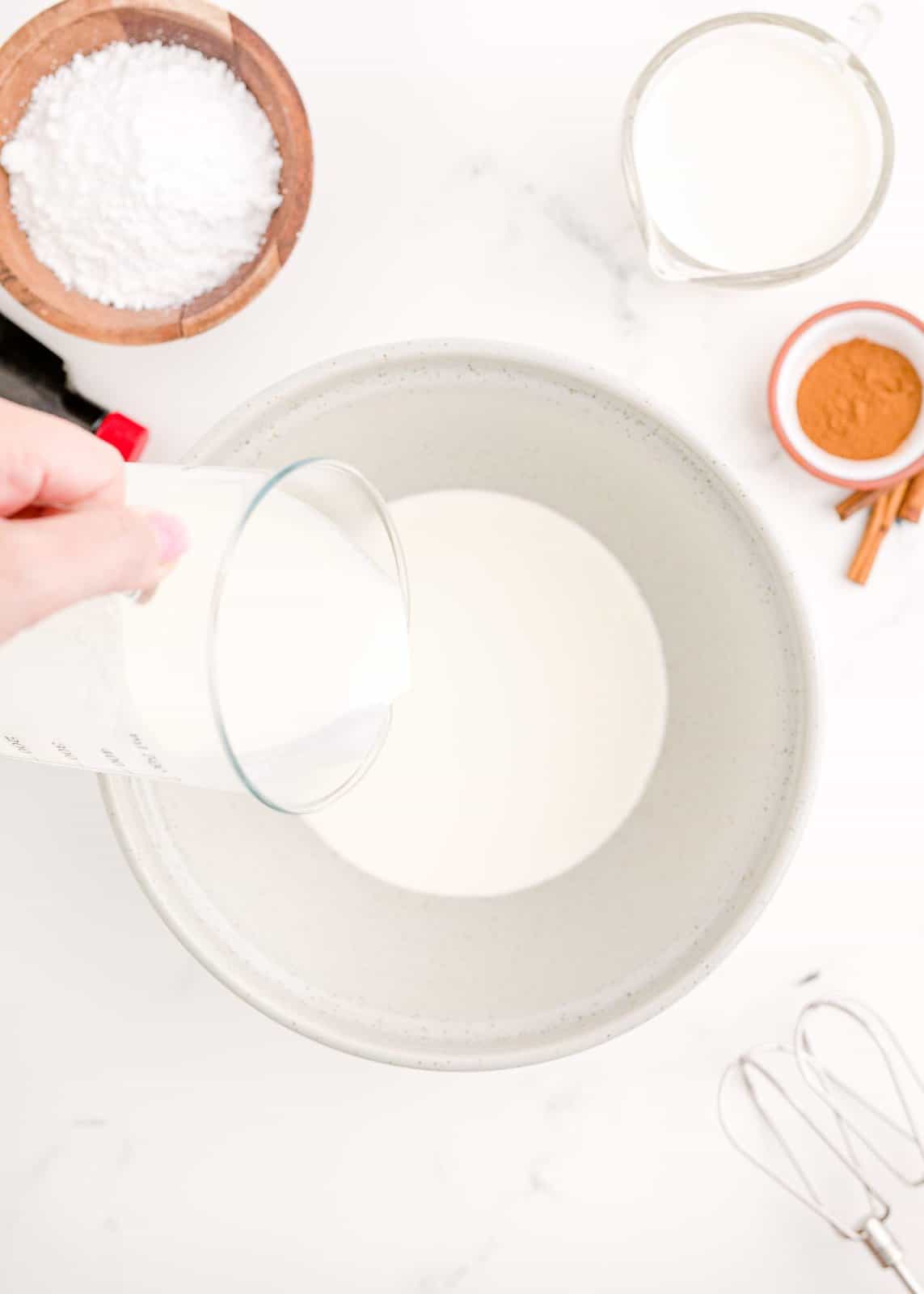 Heavy cream being poured into bowl.
