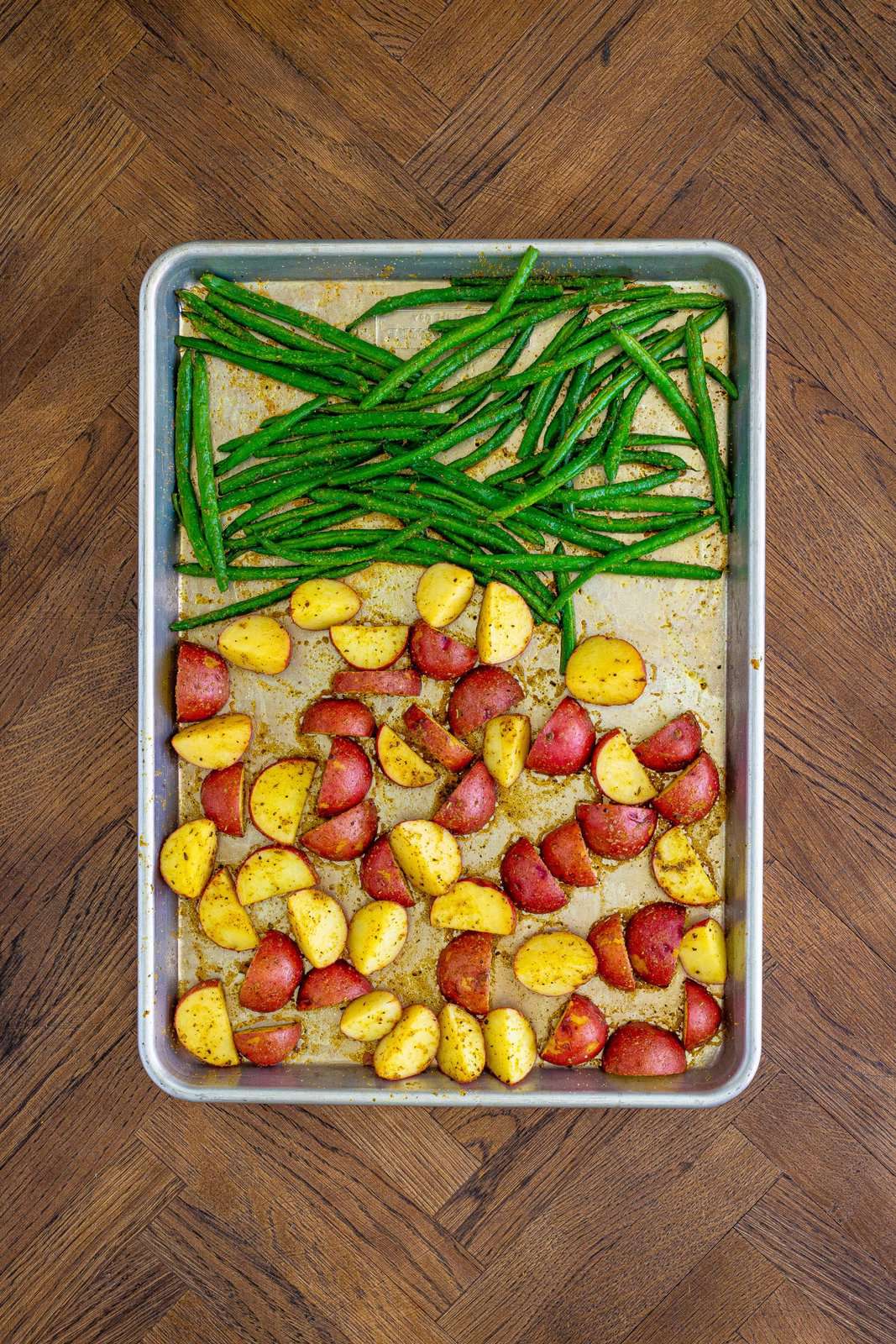 Baked green beans and potatoes out of the oven on sheet pan.