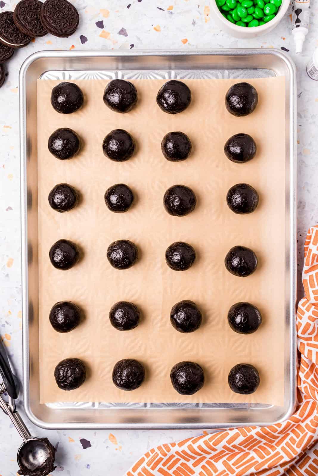 Rounded balls placed on parchment lined baking sheet.
