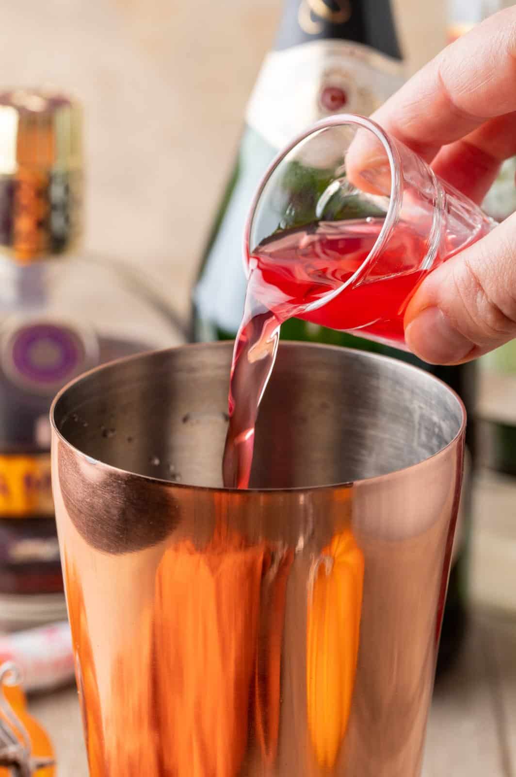 Cranberry juice being poured into the cocktail shaker.