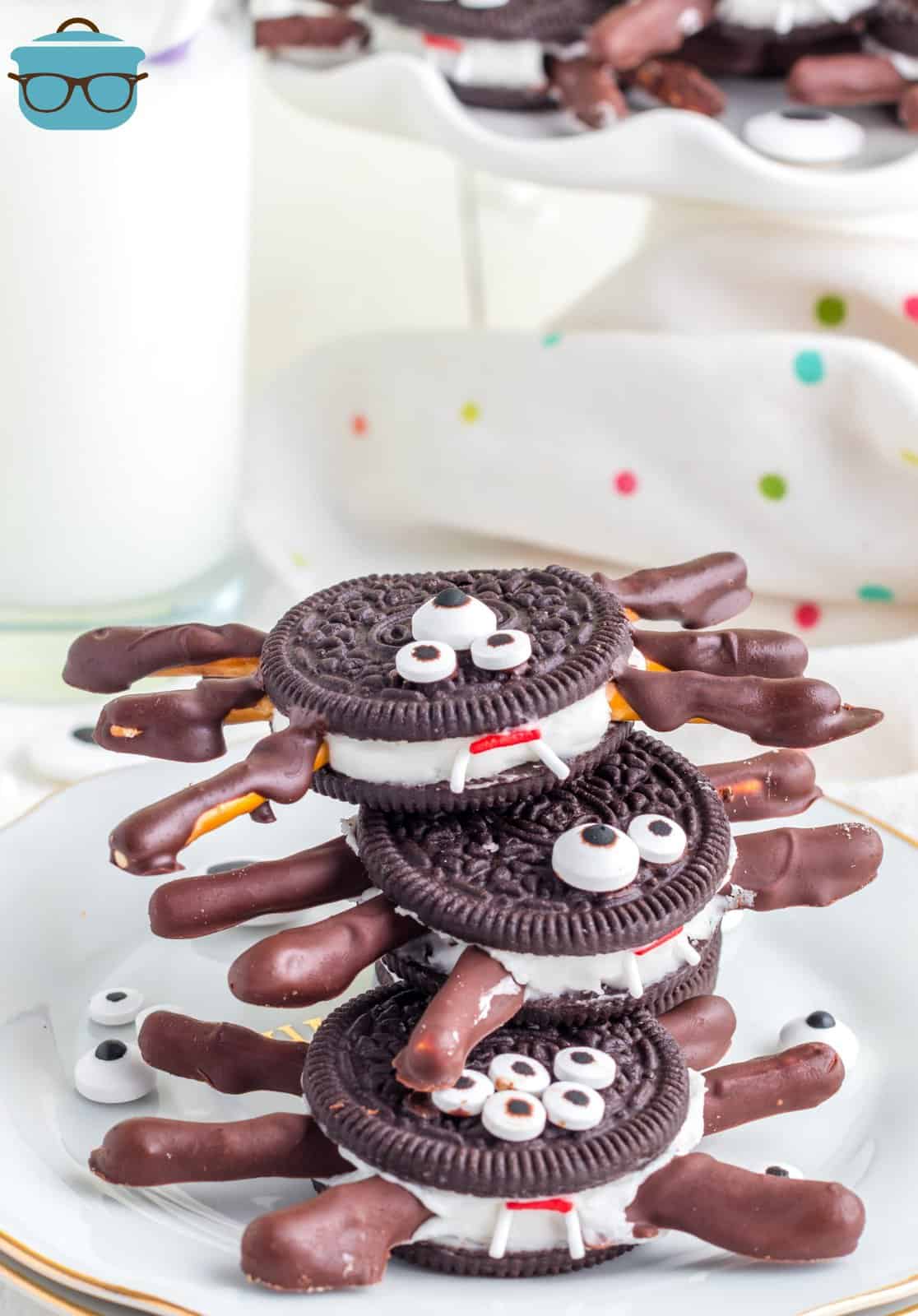 Stacked Halloween Oreo Spiders on white plate showing the fangs.