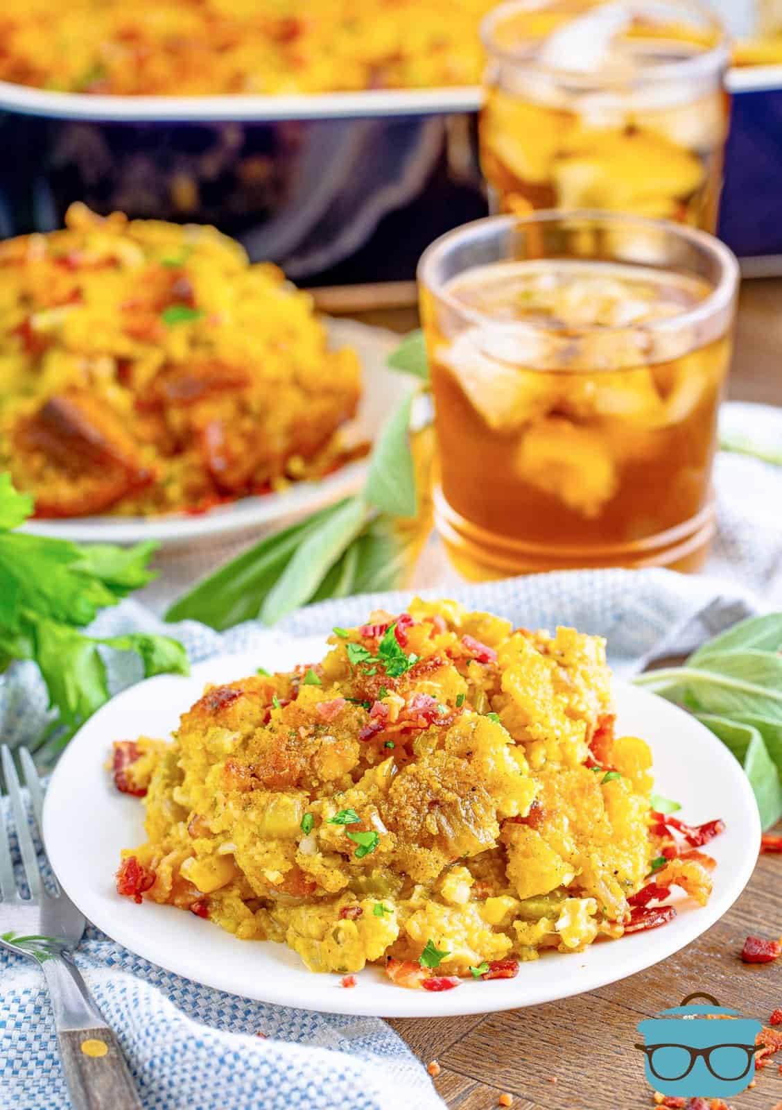 Southern Cornbread Dressing on white plate with drink in background.