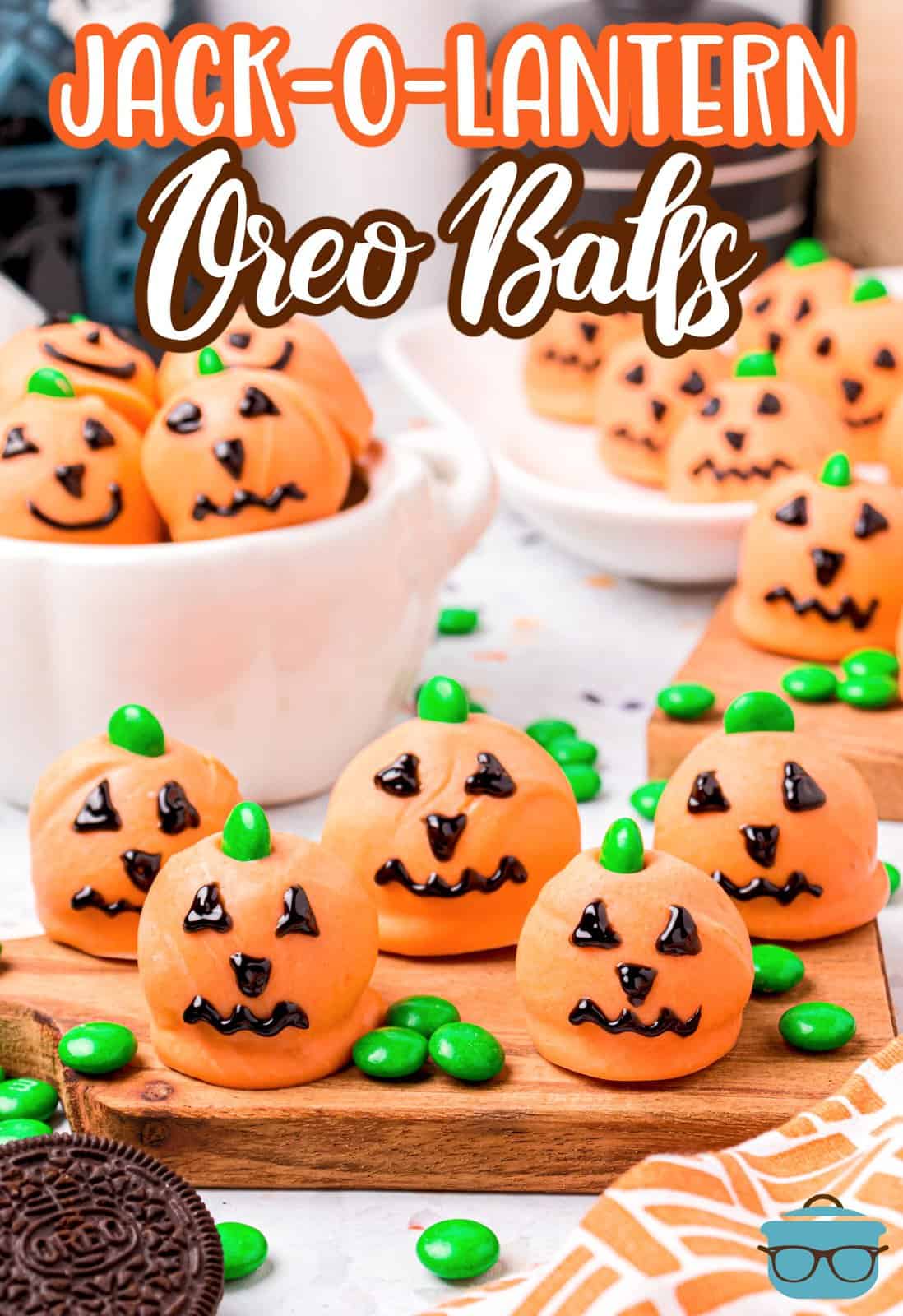 Pinterest image of Jack-O-Lantern Oreo Balls spread over wooden board with more in bowl, Pinterest image.
