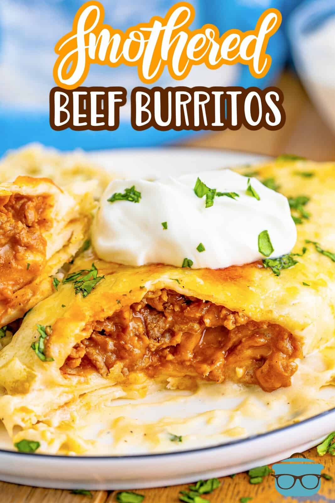 Pinterest image of one of the Smothered Beef Burritos on white plate with bite taken out of it showing filling.
