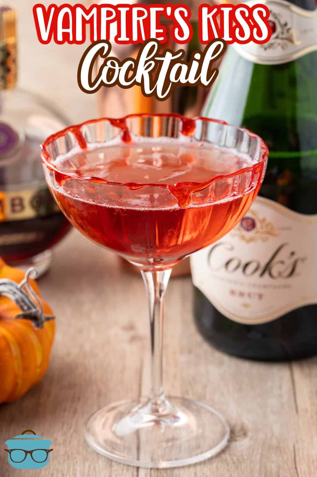 Pinterest image of the Vampire's Kiss Cocktail in tall glass with alcohol bottles in background.