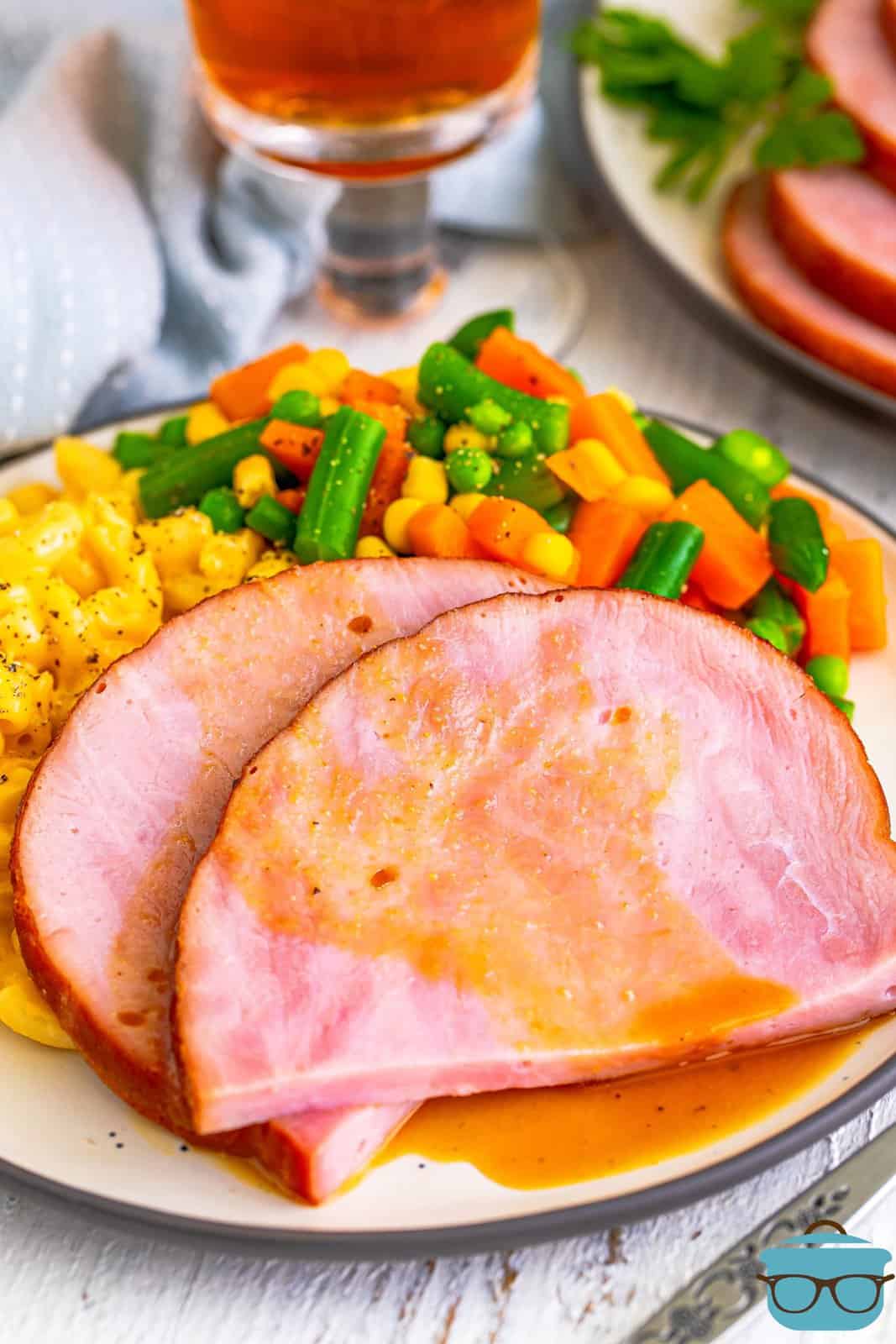 Slow Cooker Boneless Ham slices on plate with sides.
