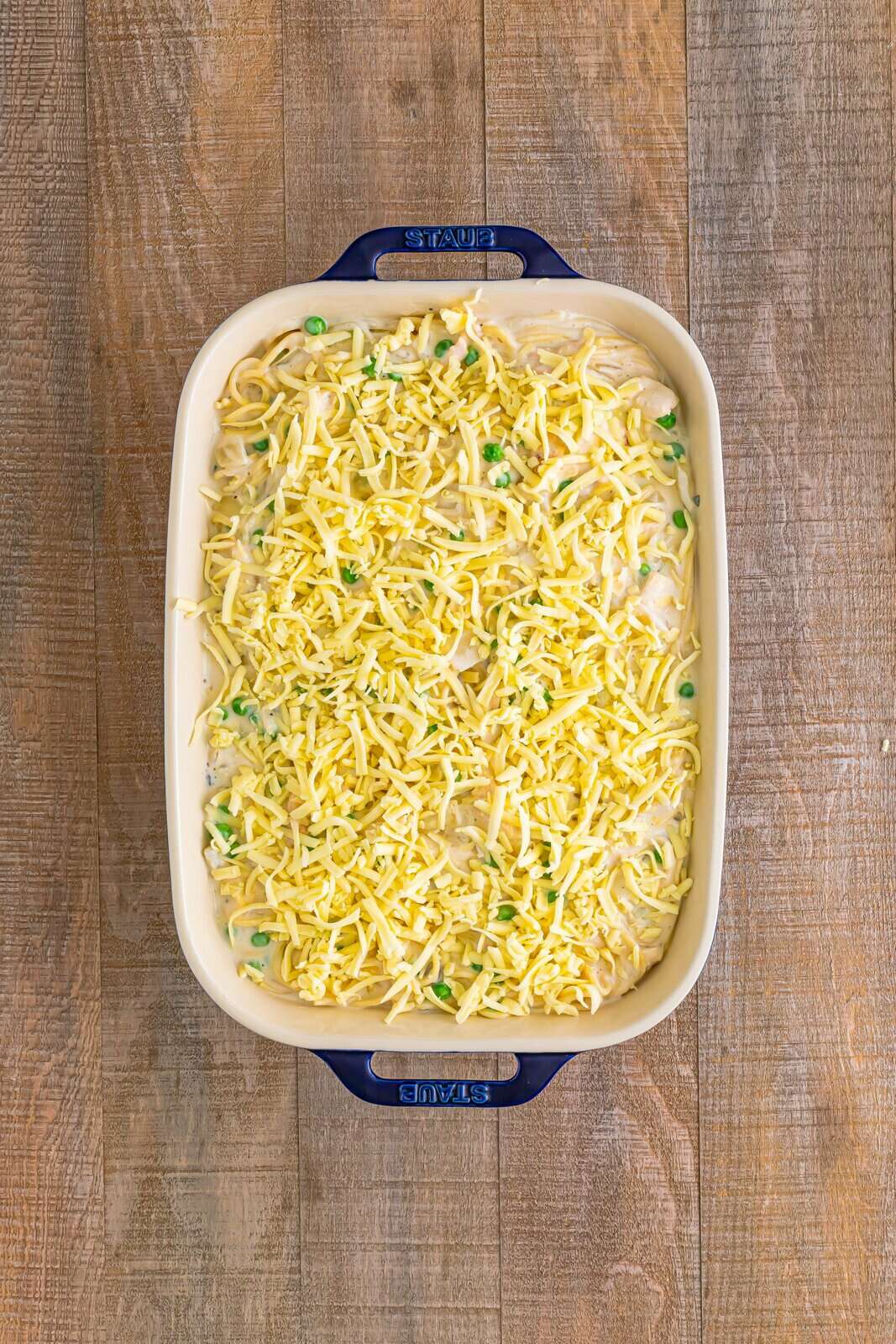 Mixture added to prepared baking dish with cheese sprinkled on top.