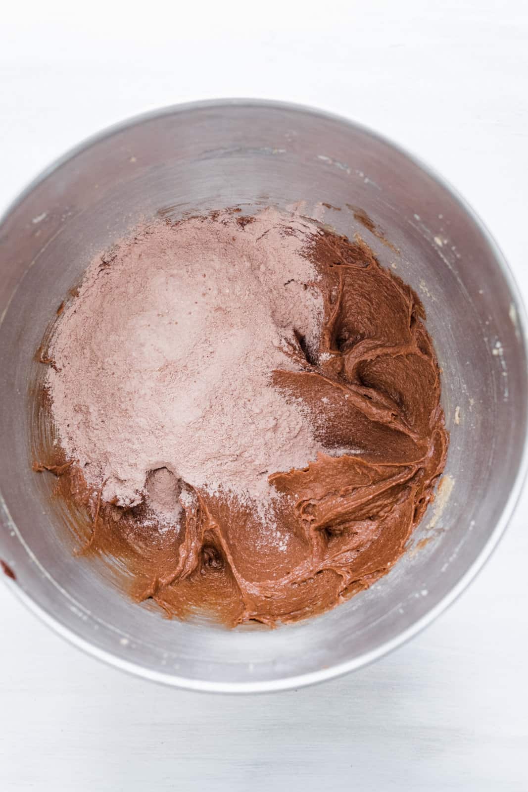 Flour and cocoa powder mixture added to bowl of stand mixer.