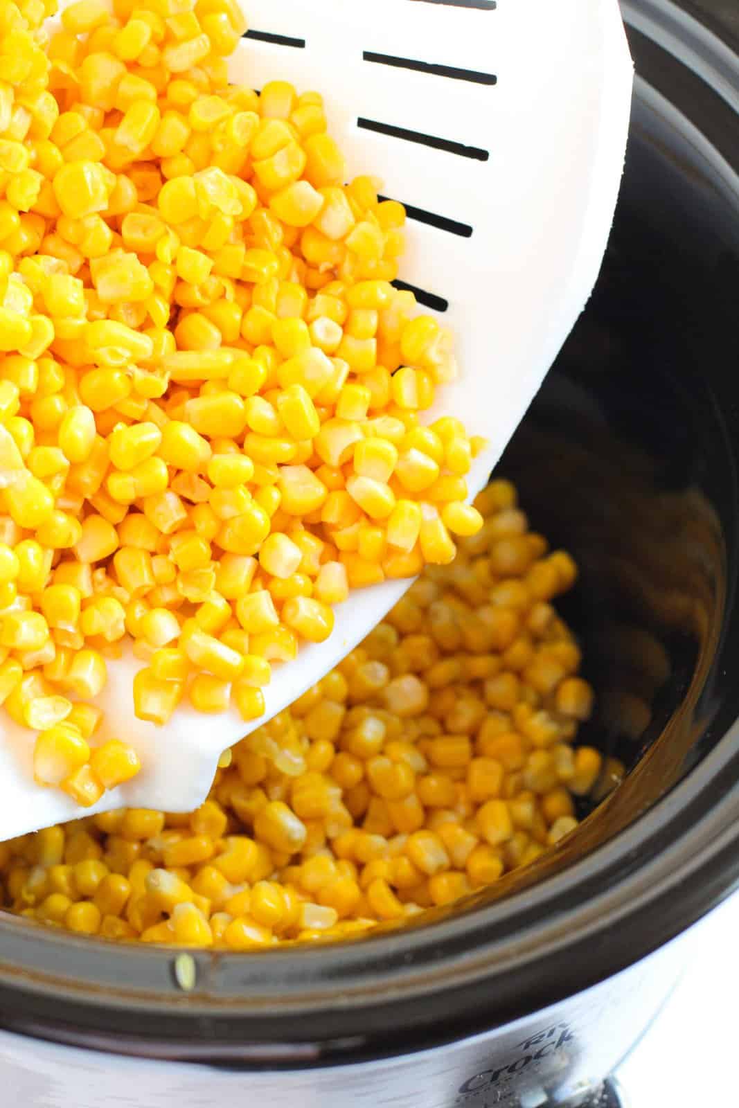 Corn being poured into crock pot.