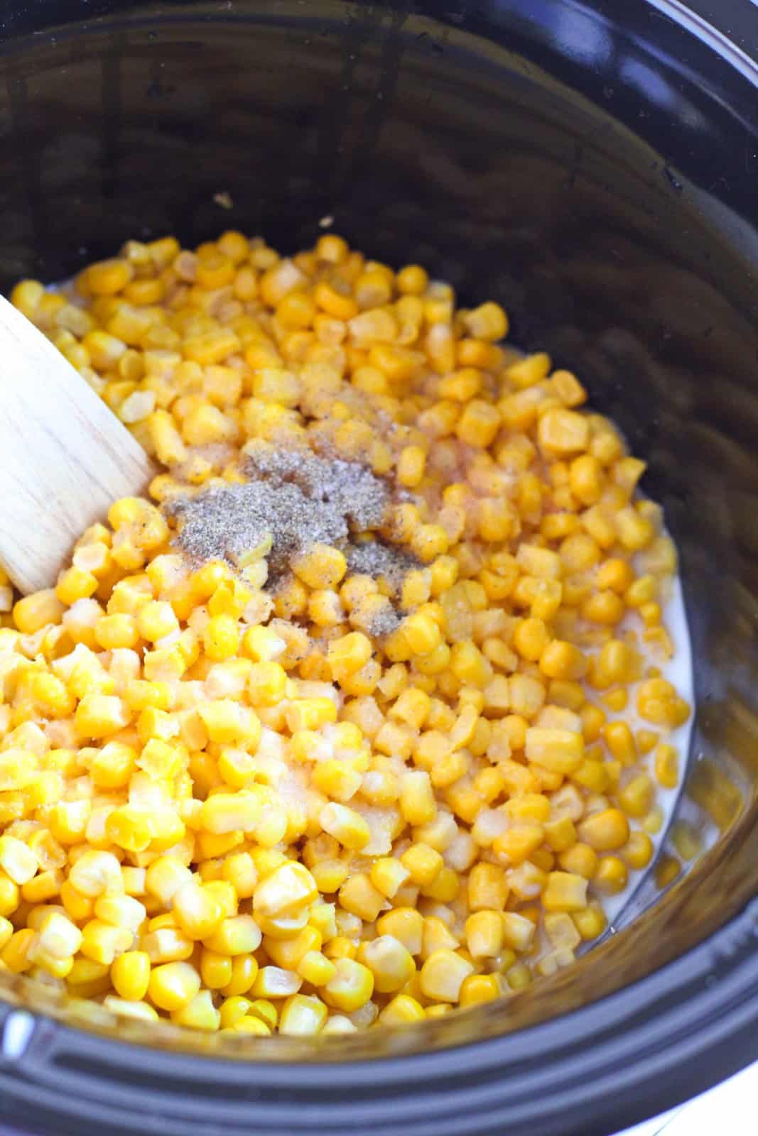 Sugar, salt and pepper added to corn in crock pot.