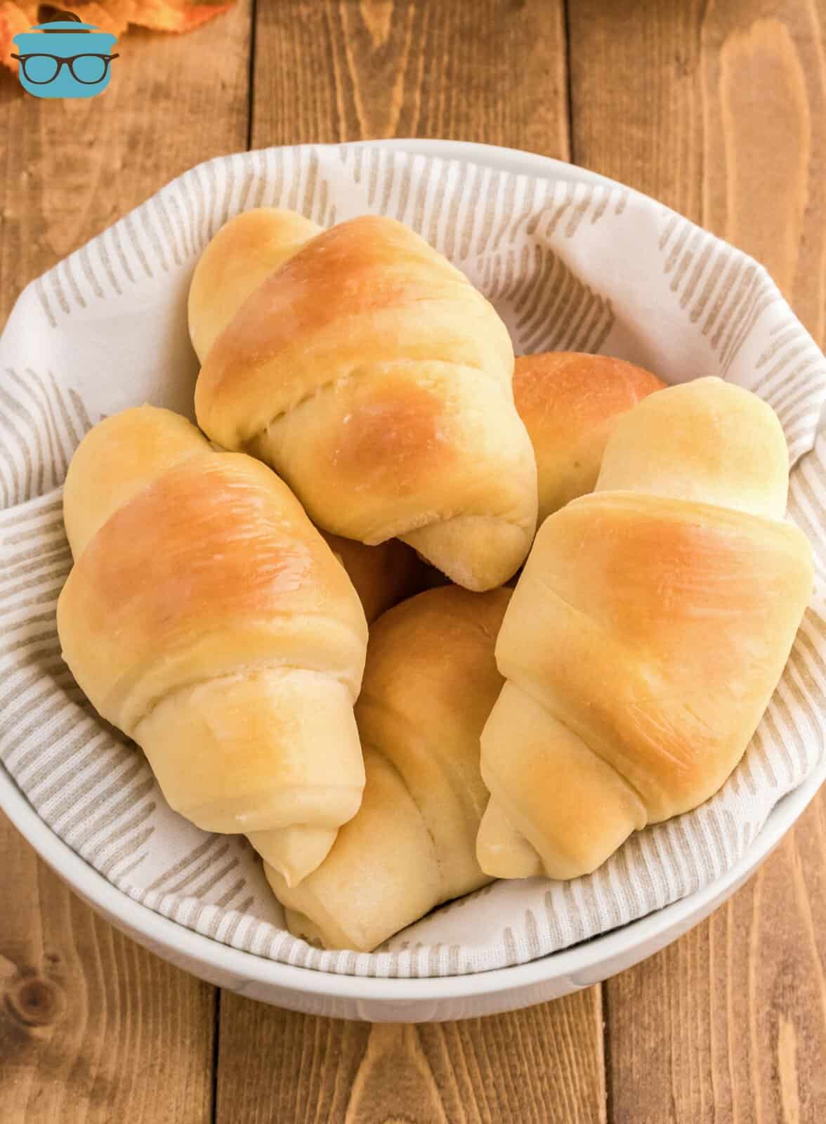 Stacked Homemade Crescent Rolls in linen lined bowl.