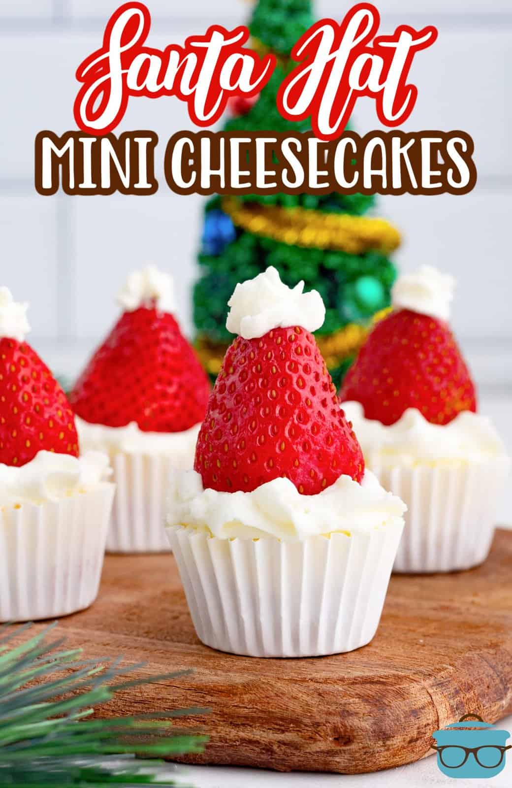 Pinterest image of Santa Hat Mini Cheesecakes on wooden board garnished.