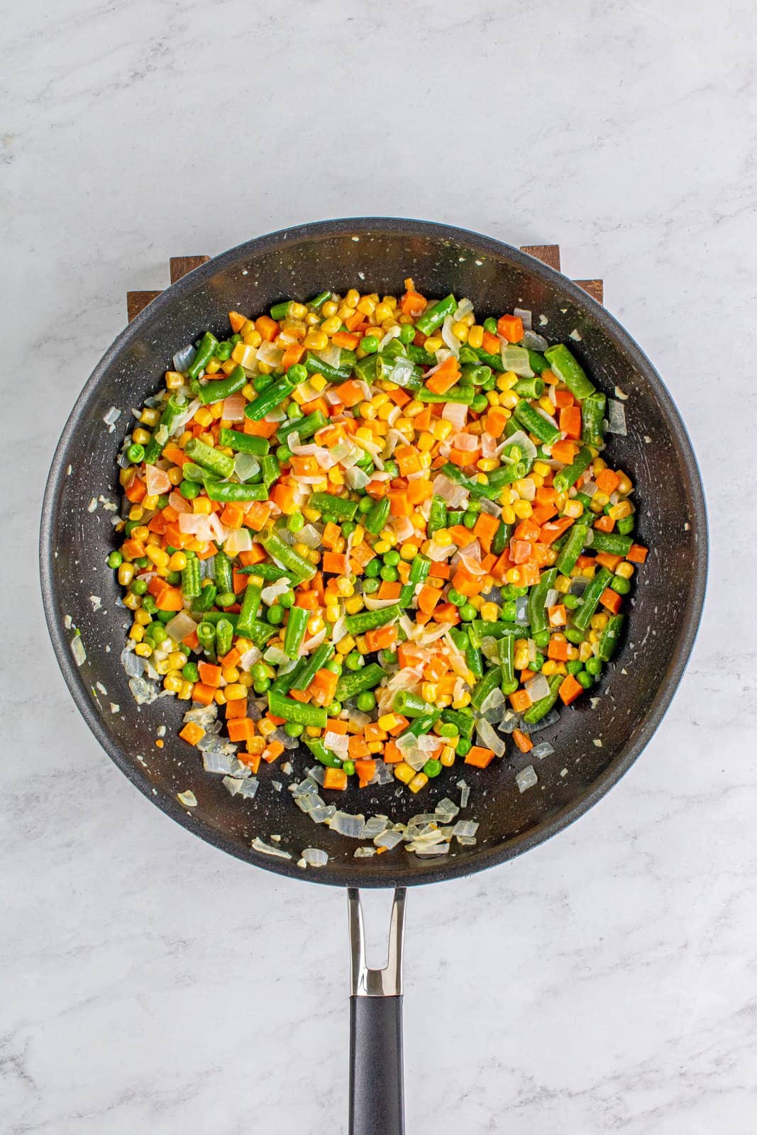 Frozen vegetables added to pan.
