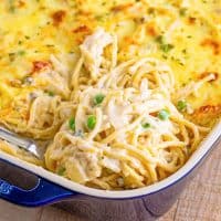 Close up square image of Easy Chicken Tetrazzini in baking dish with serving spoon pulling some out.