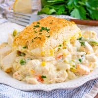 Close up square image of Turkey Pot Pie Casserole on white plate with parsley.
