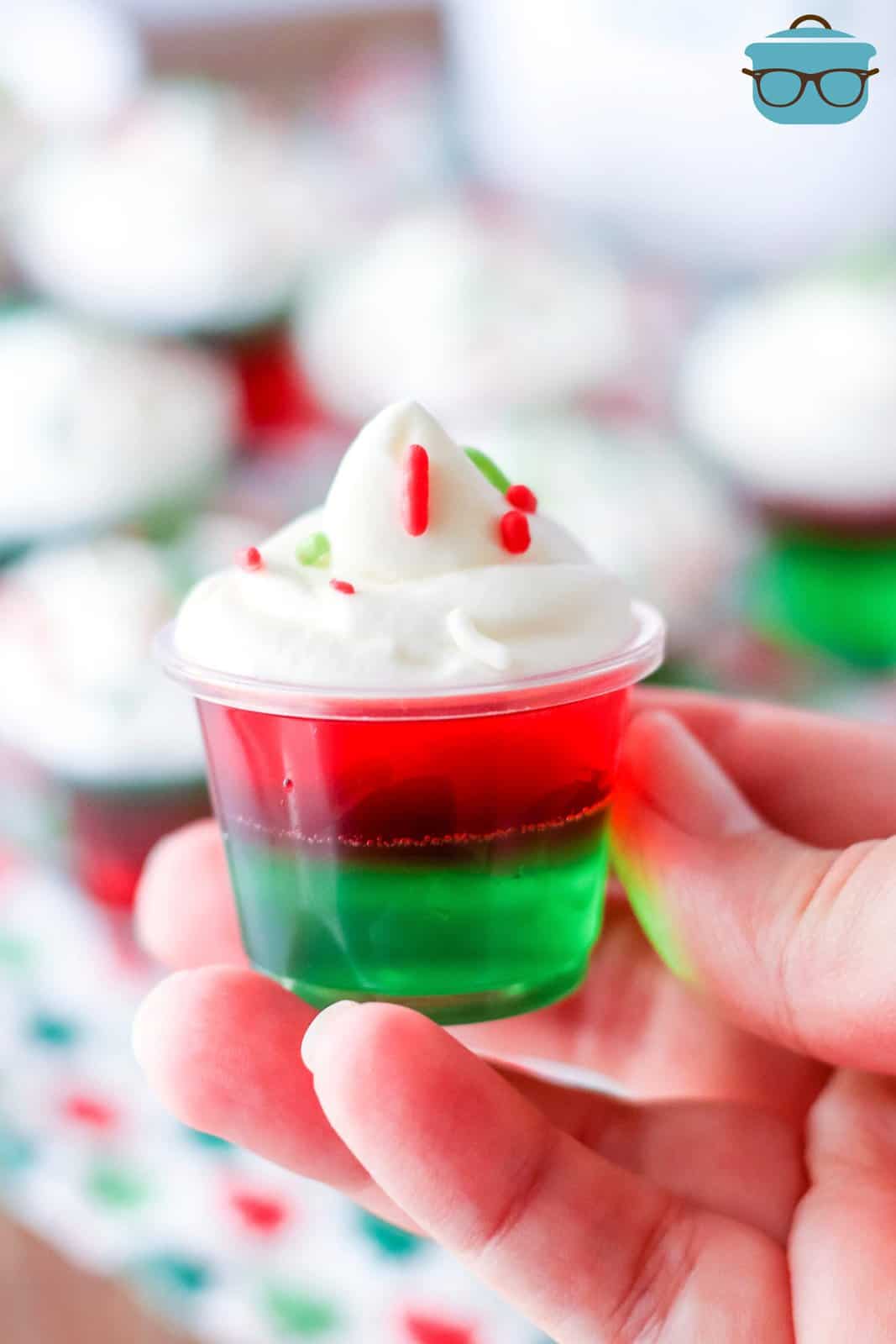 Hand holding up one of the Holiday Jell-O shots.