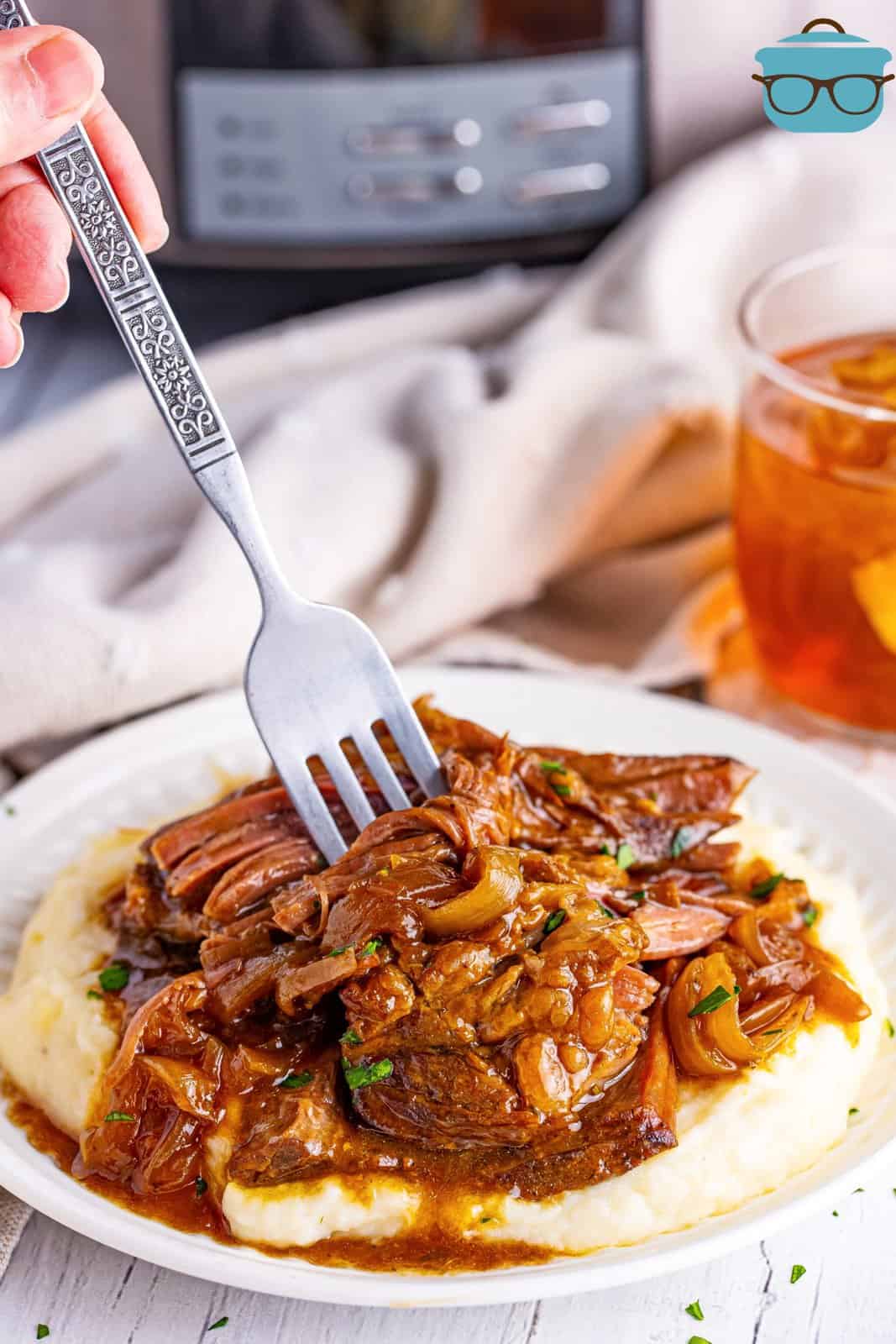 A fork placed in a serving of shredded French Onion Pot Roast.