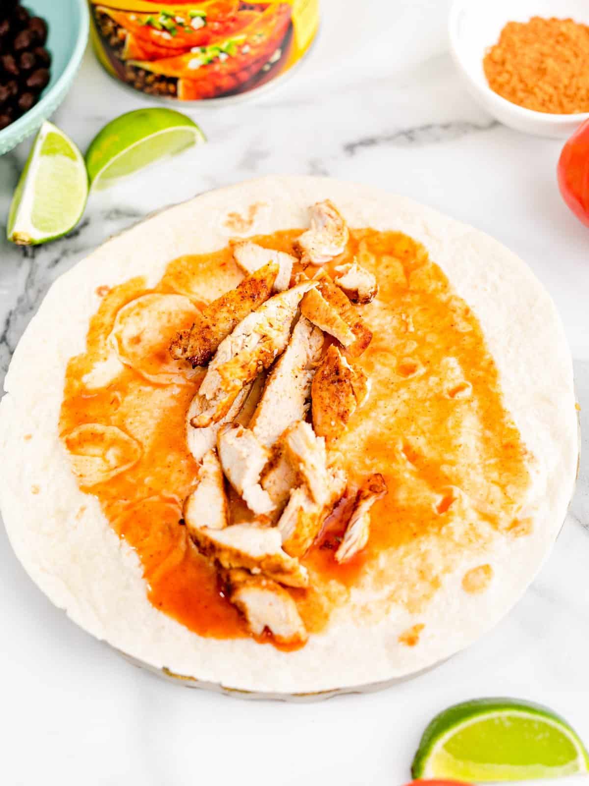 sliced chicken placed in the center of the flour tortilla.