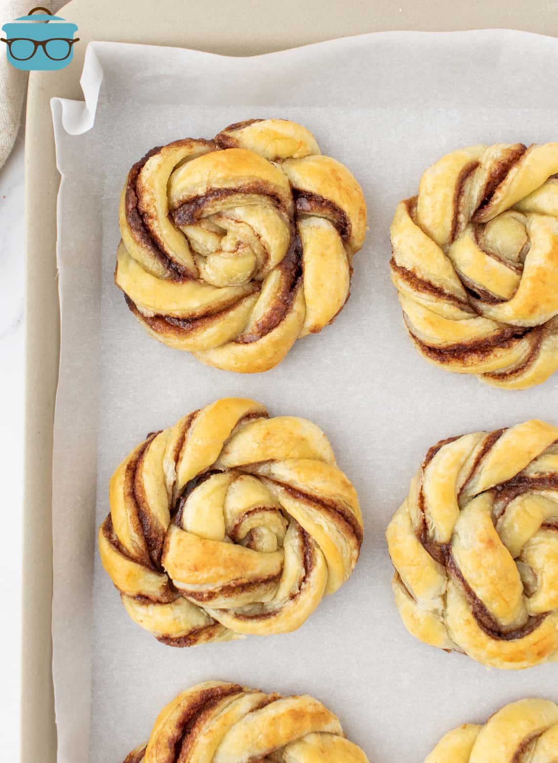 fully baked cinnamon knots shown on a baking sheet. 