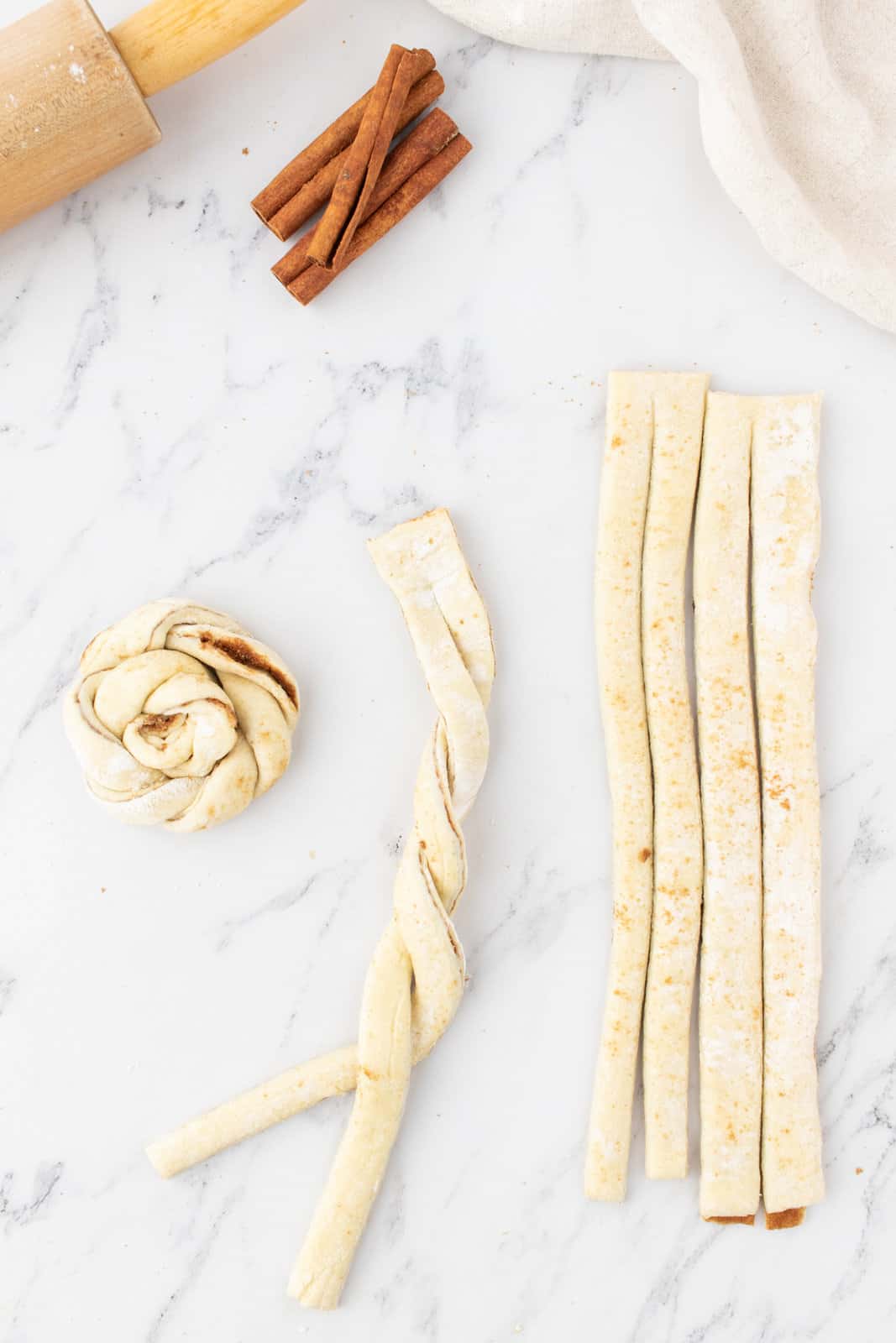 showing two puff pastry strips being twirled around each other.