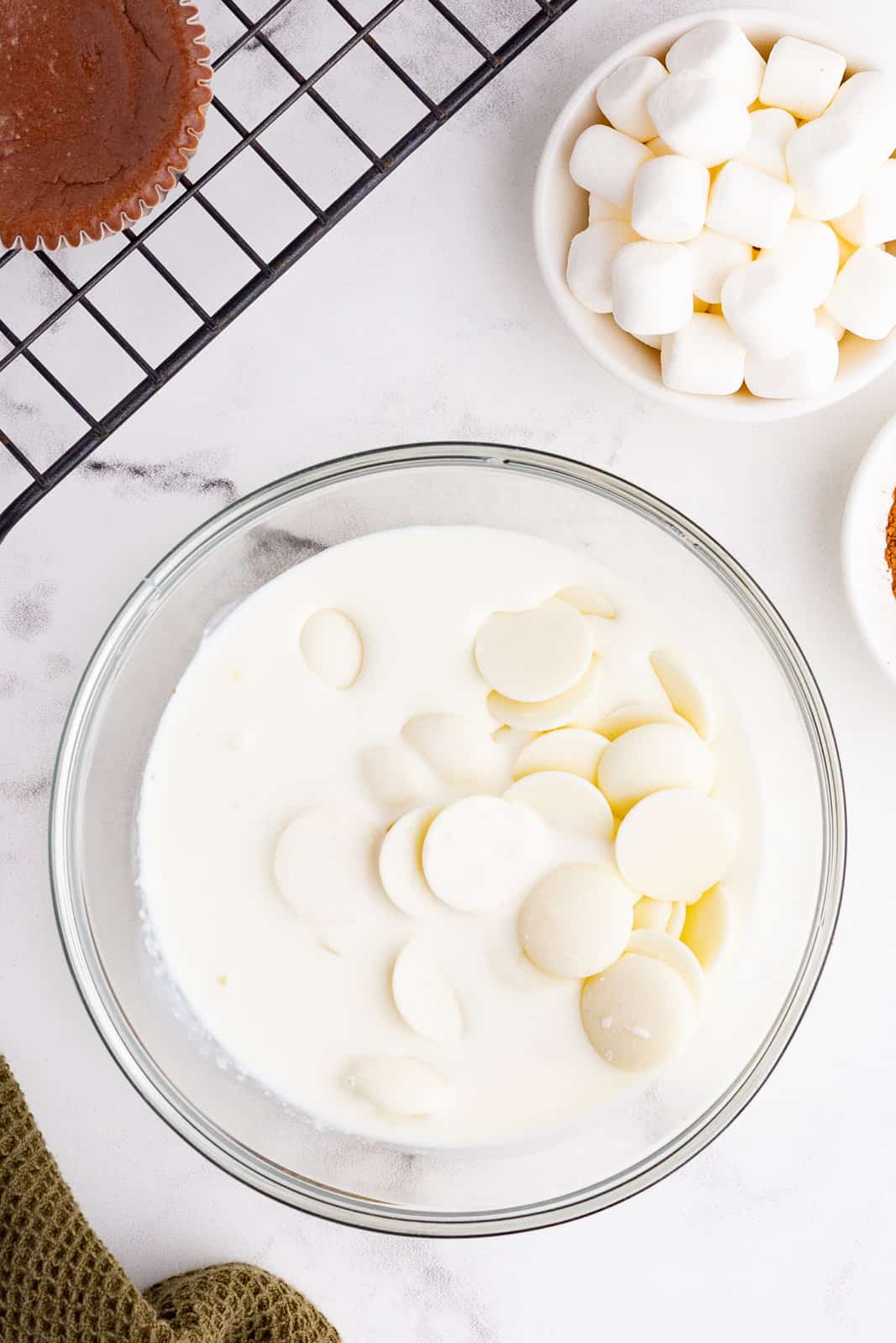 white chocolate wafers and heavy cream in a clear bowl. 