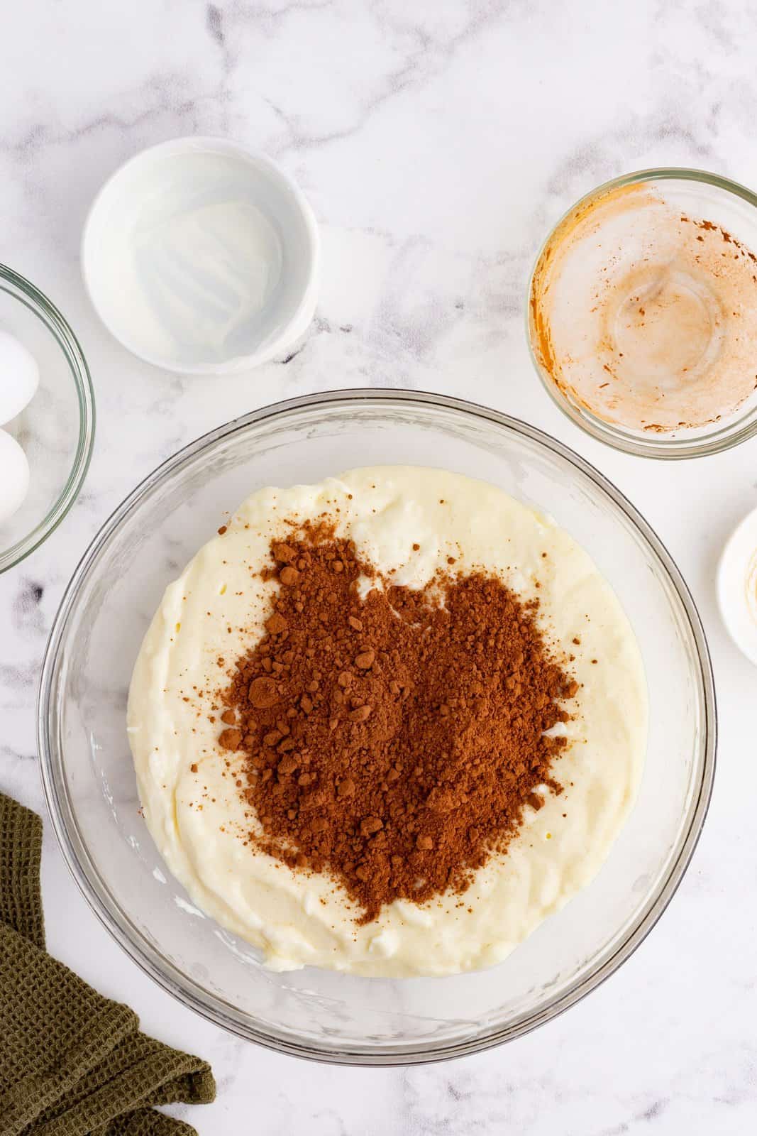 cocoa powder added to cream cheese mixture in a bowl.