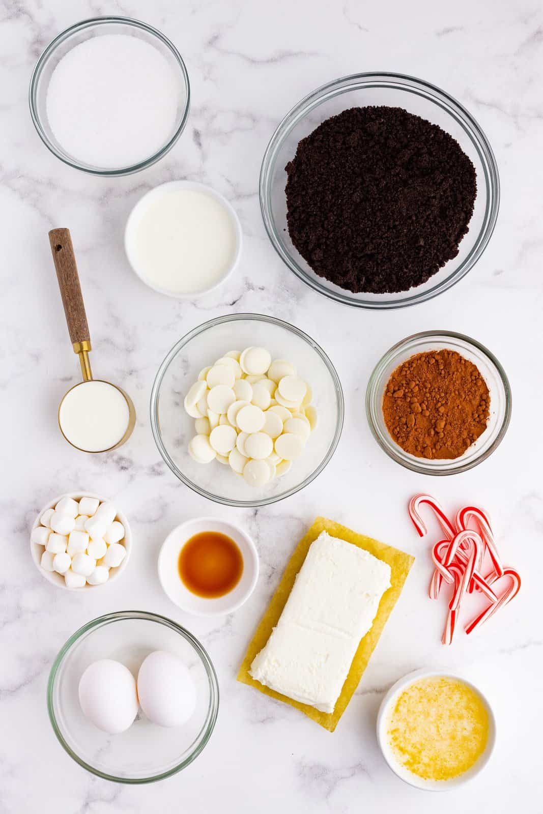 Oreo cookie crumbs, white chocolate, cocoa powder, cream cheese, sour cream, sugar, mini marshmallows, mini candy canes, butter.