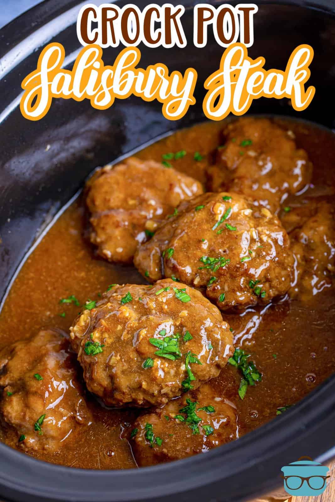 fully cooked salisbury steaks with gravy shown in a black, oval slow cooker. 