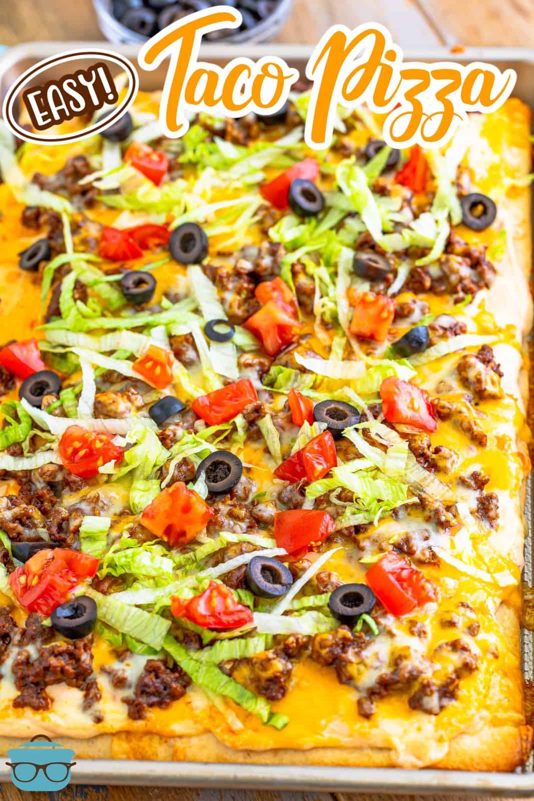 a fully made beef taco pizza shown in a baking pan.