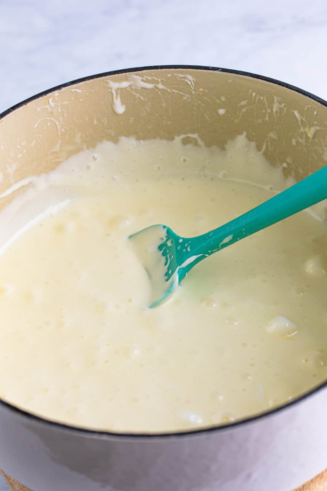 Melted butter and marshmallows in a pot with spatula.