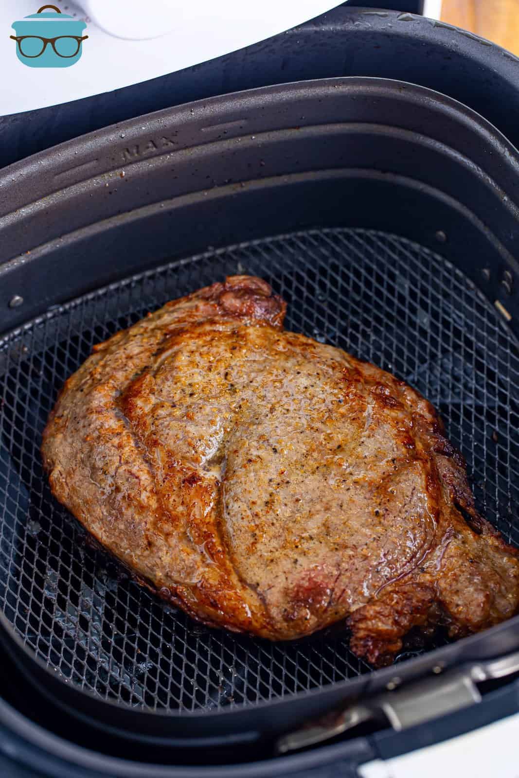 A perfectly cooked Ribeye Steak in the Air Fryer basket.
